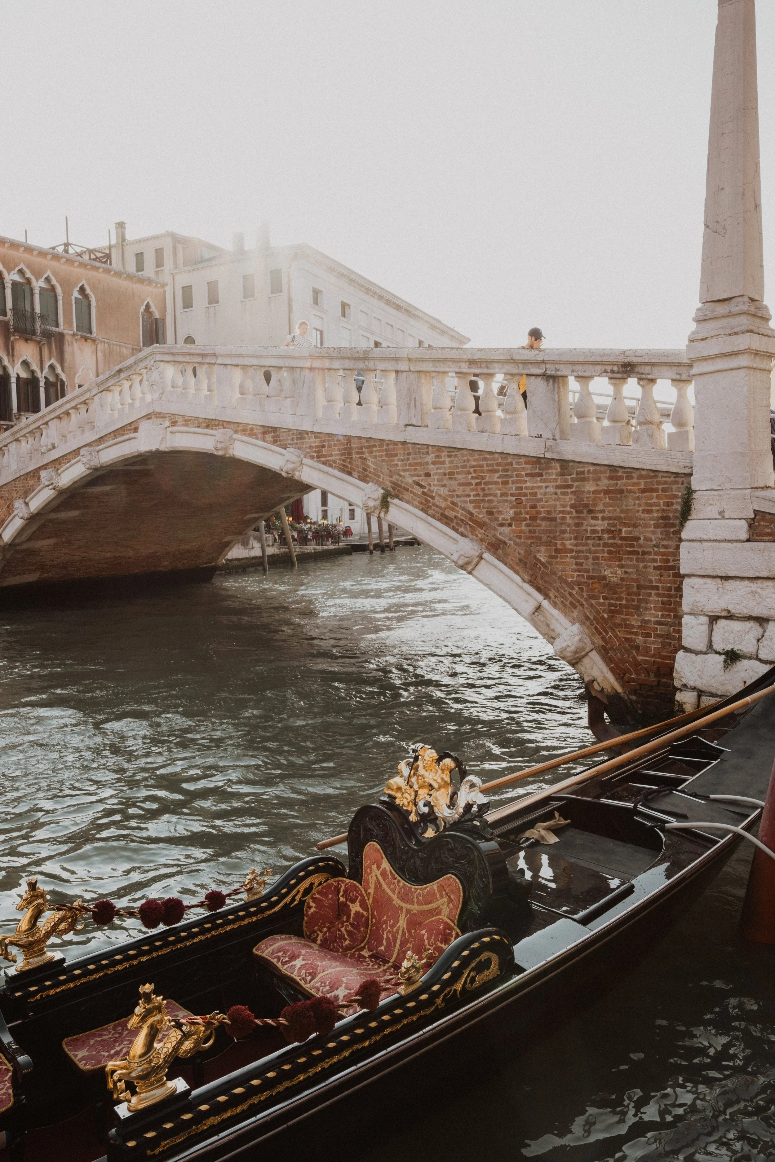 A quiet Venetian canal scene with a traditional gondola beneath a historic bridge, evoking the timeless romance and refined atmosphere of an intimate luxury wedding in Venice.