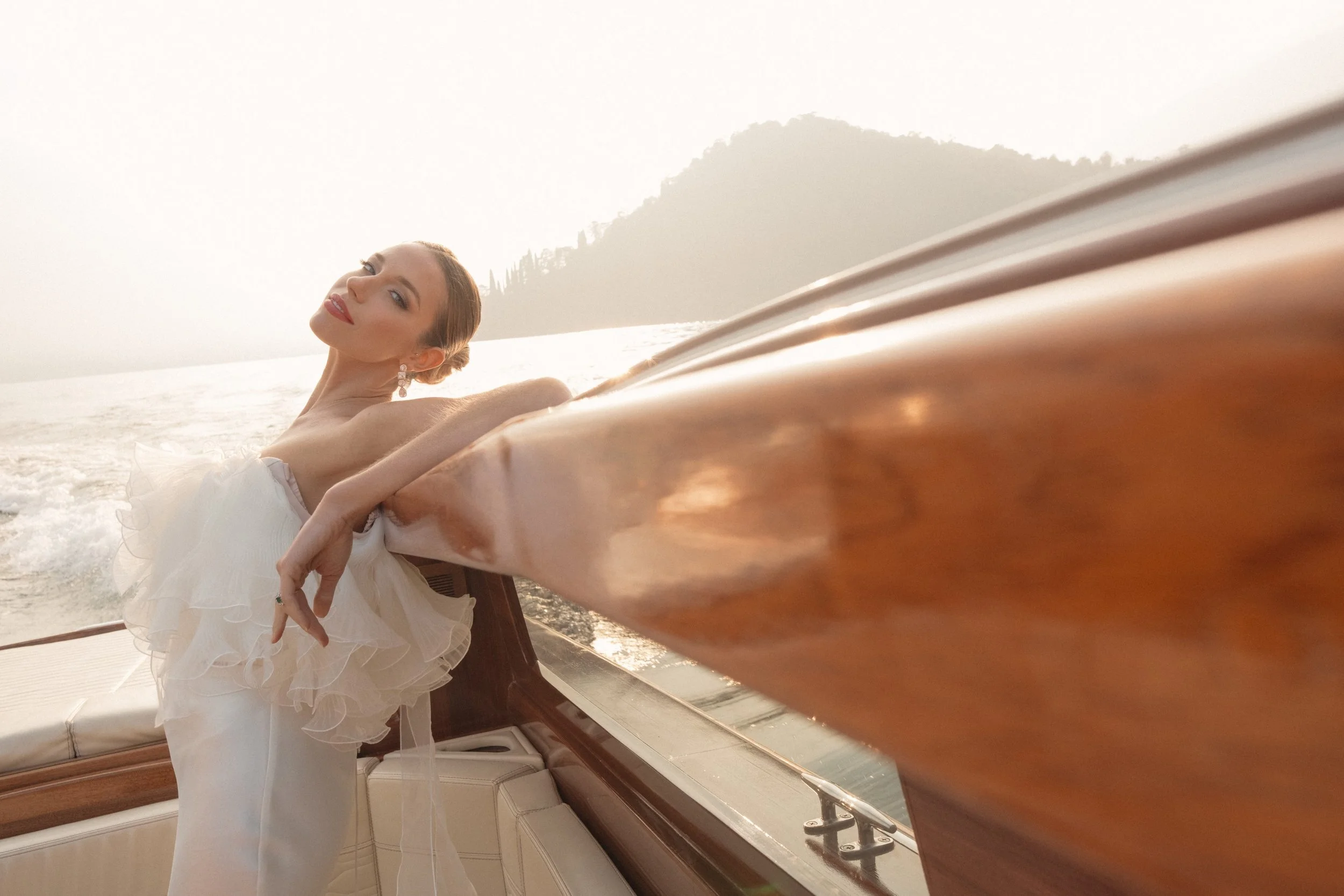 An editorial bridal portrait captured on Lake Como at Villa Pizzo, where soft sunset light, water reflections, and refined styling come together in a timeless, fashion-inspired wedding moment on the lake.