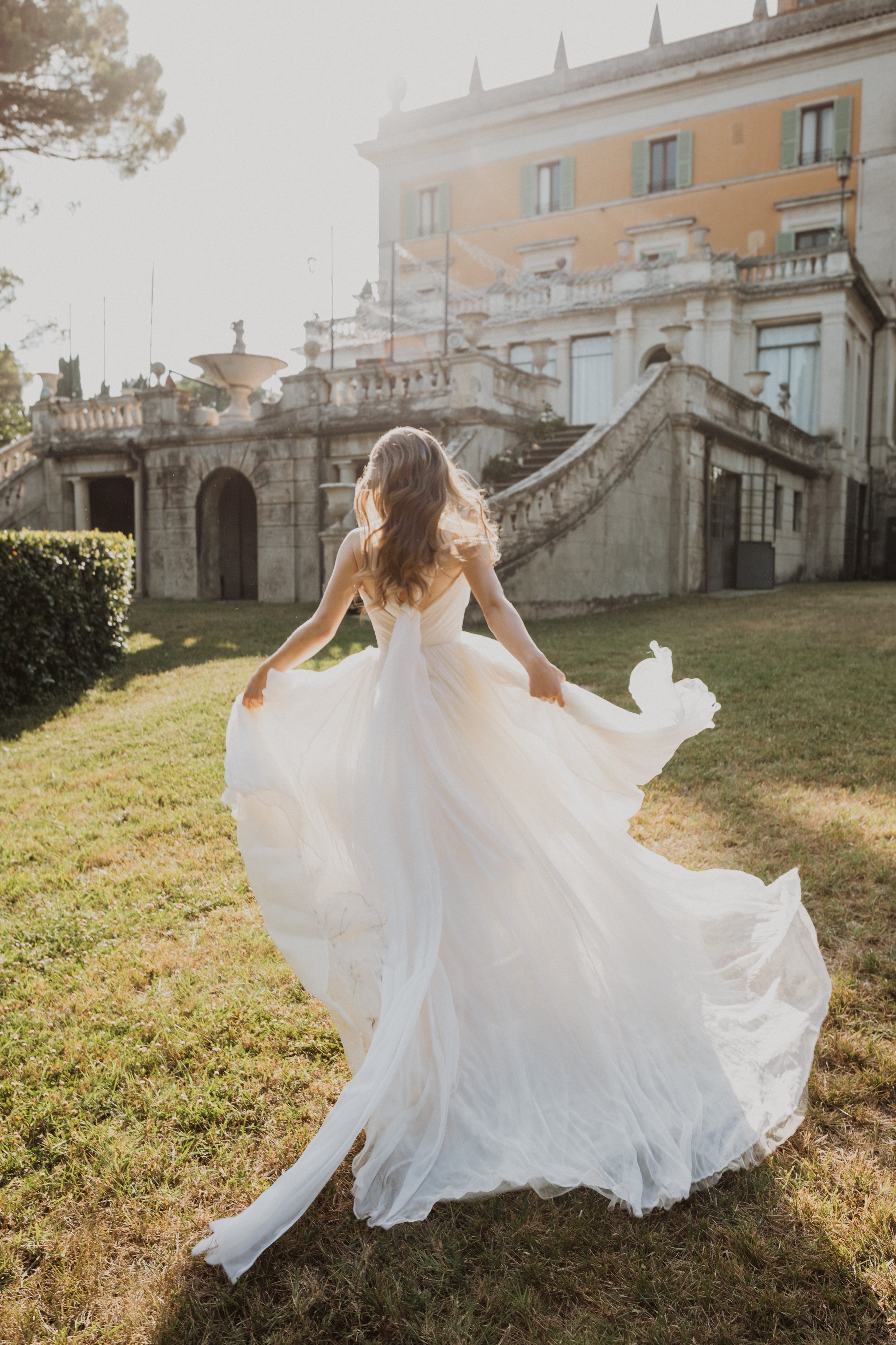 Bridal Flowing Dress in Front of Torre di Pila | Elegant Destination Wedding Photography