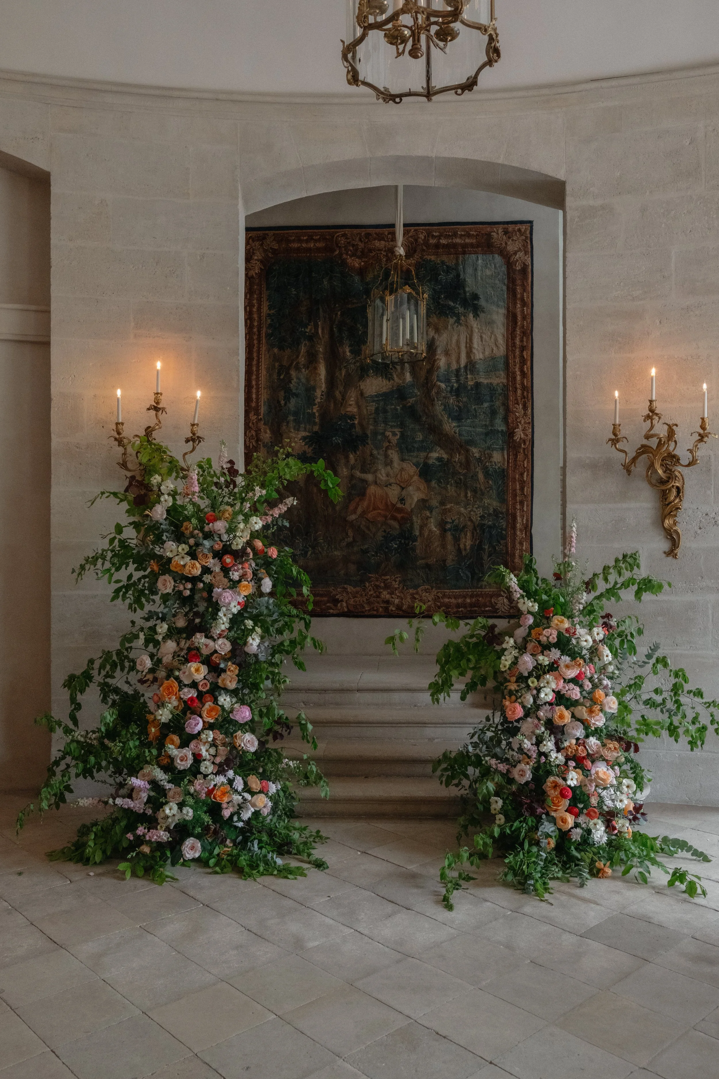 Refined floral ceremony installation inside a historic European venue, designed for a luxury and distinctive wedding celebration.
