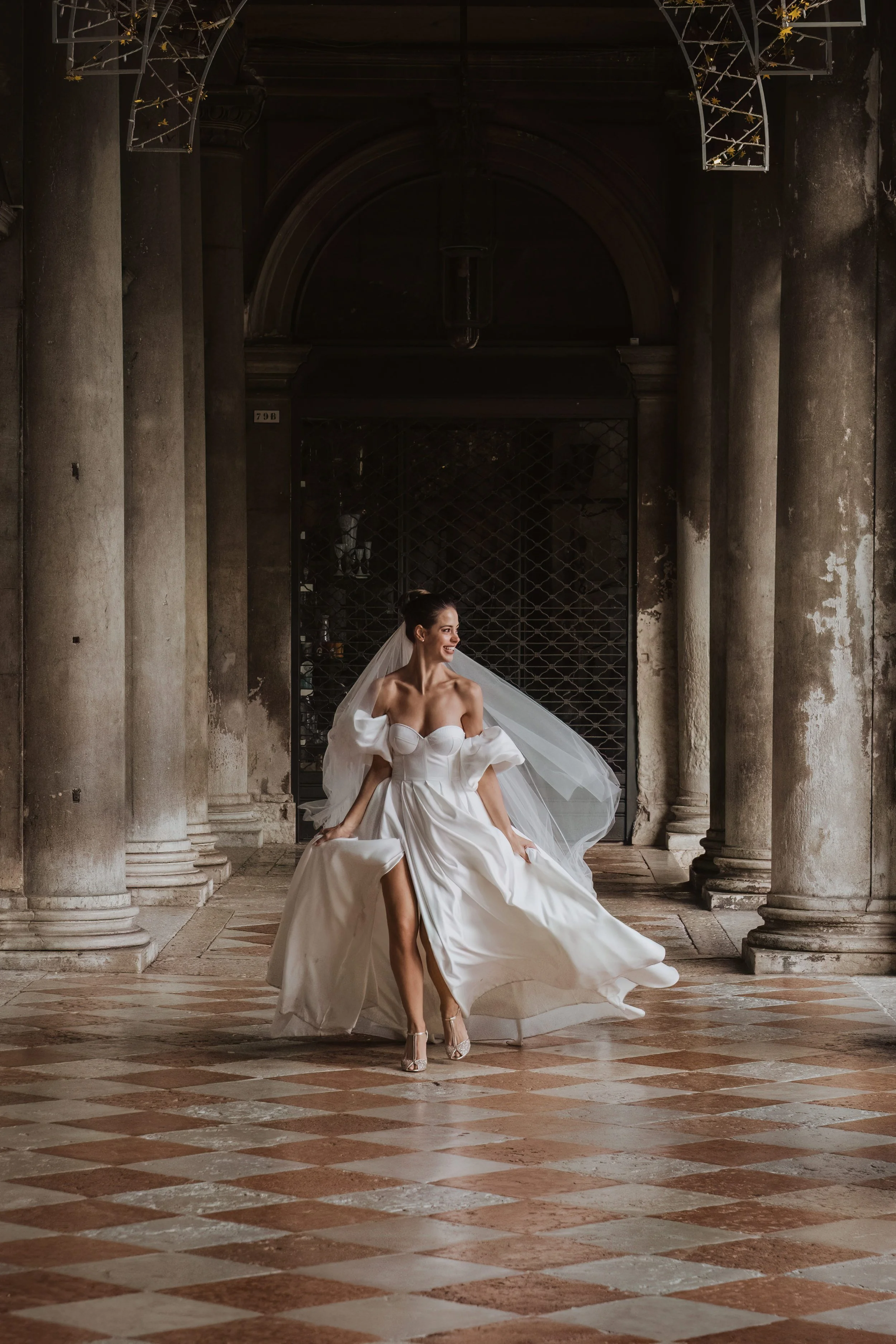 Bridal Portrait in Venice | Bride in Flowing Wedding Dress Walking Through Archway