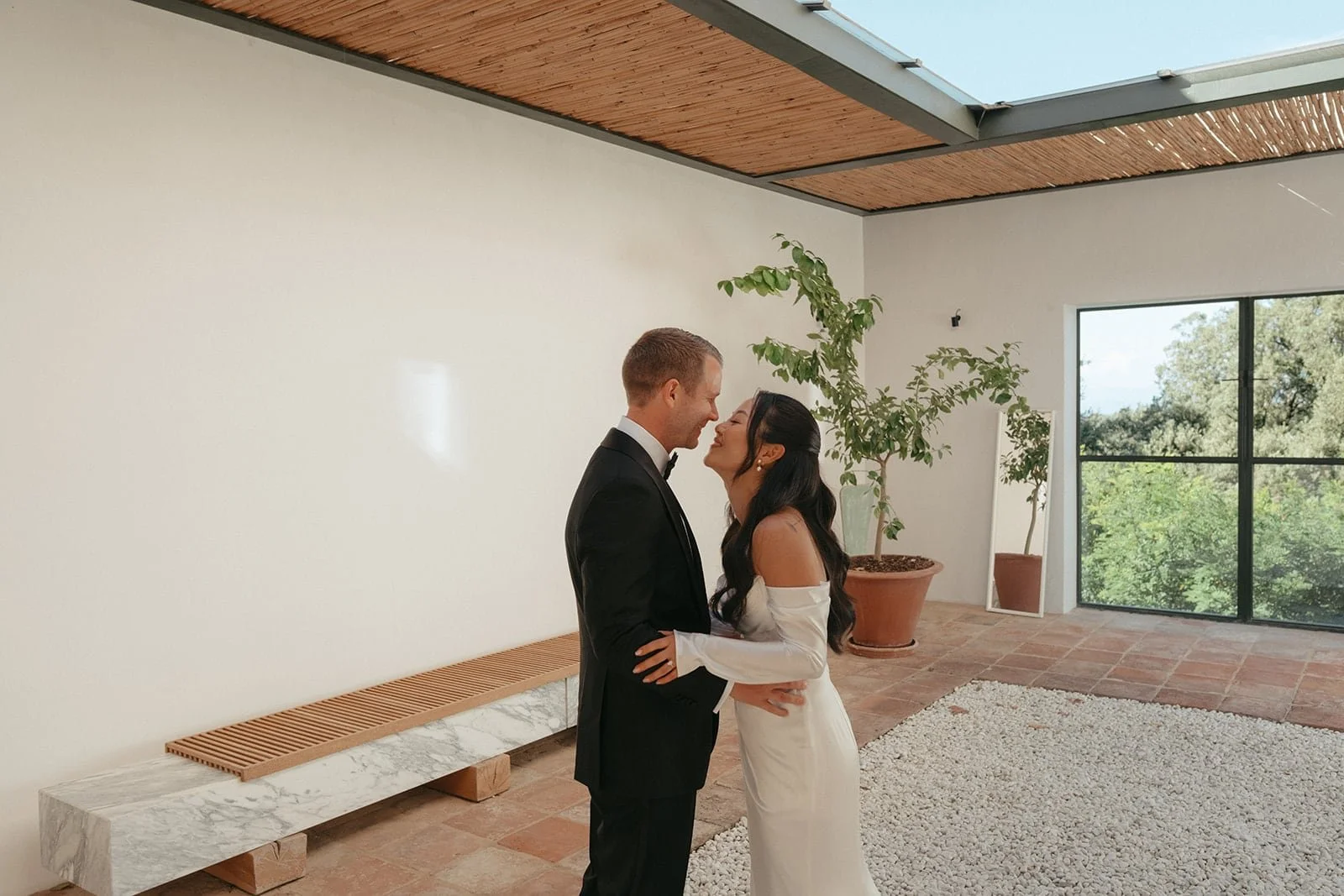The bride and groom stand facing each other for an intimate first look inside Villa Lena, captured in soft light and a calm, modern atmosphere.