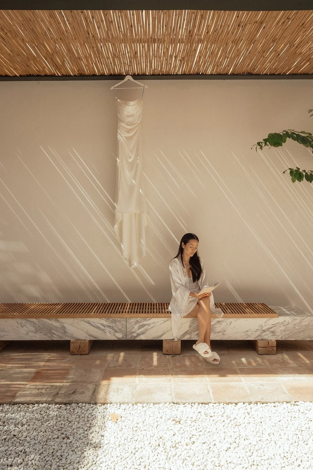 A quiet black and white portrait of the bride seated alone, surrounded by clean lines and Tuscan light.
