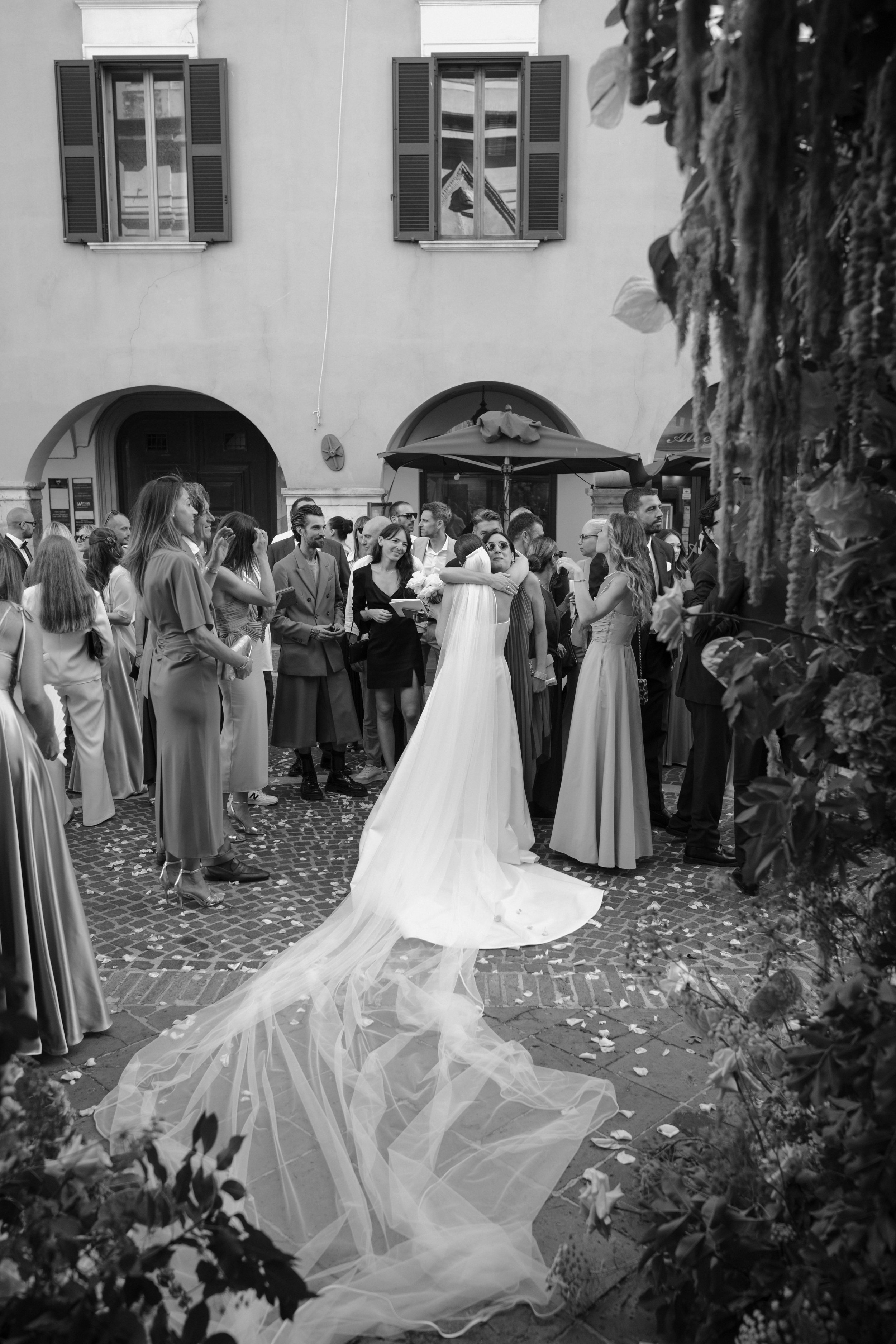 A heartfelt moment after a church ceremony in a Tuscan square, capturing emotion, connection, and authentic destination wedding storytelling.
