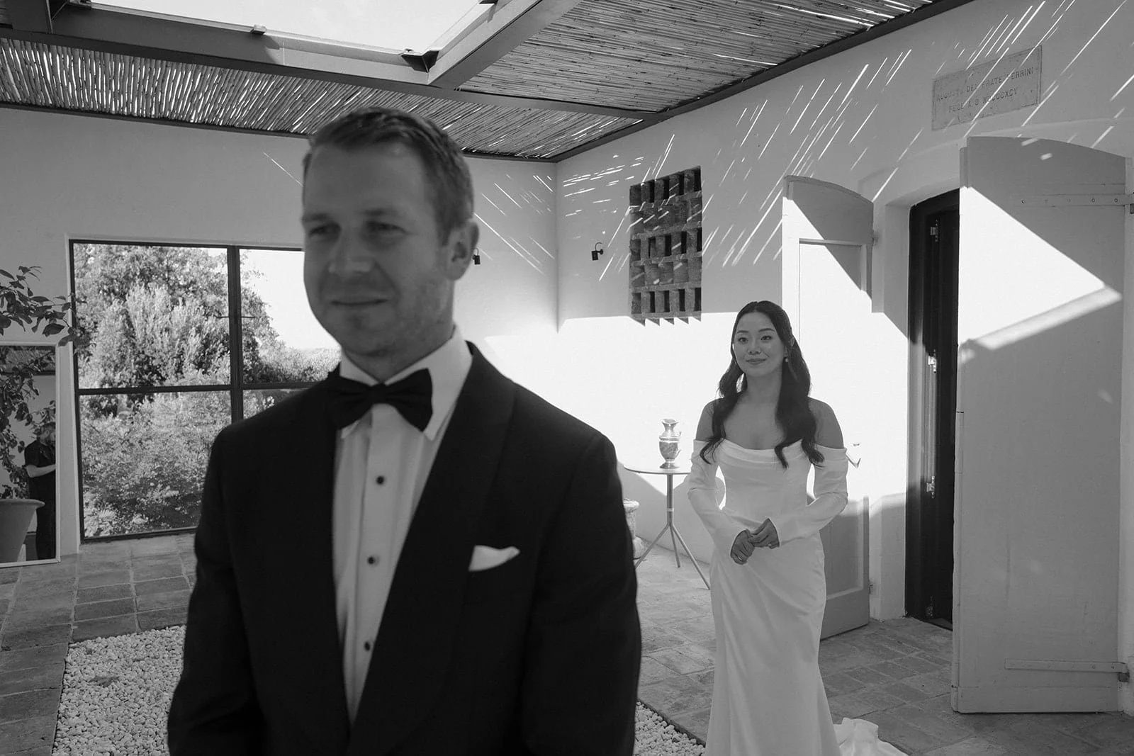 The bride and groom stand together moments before the ceremony, photographed inside Villa Lena with natural light filtering through the space.