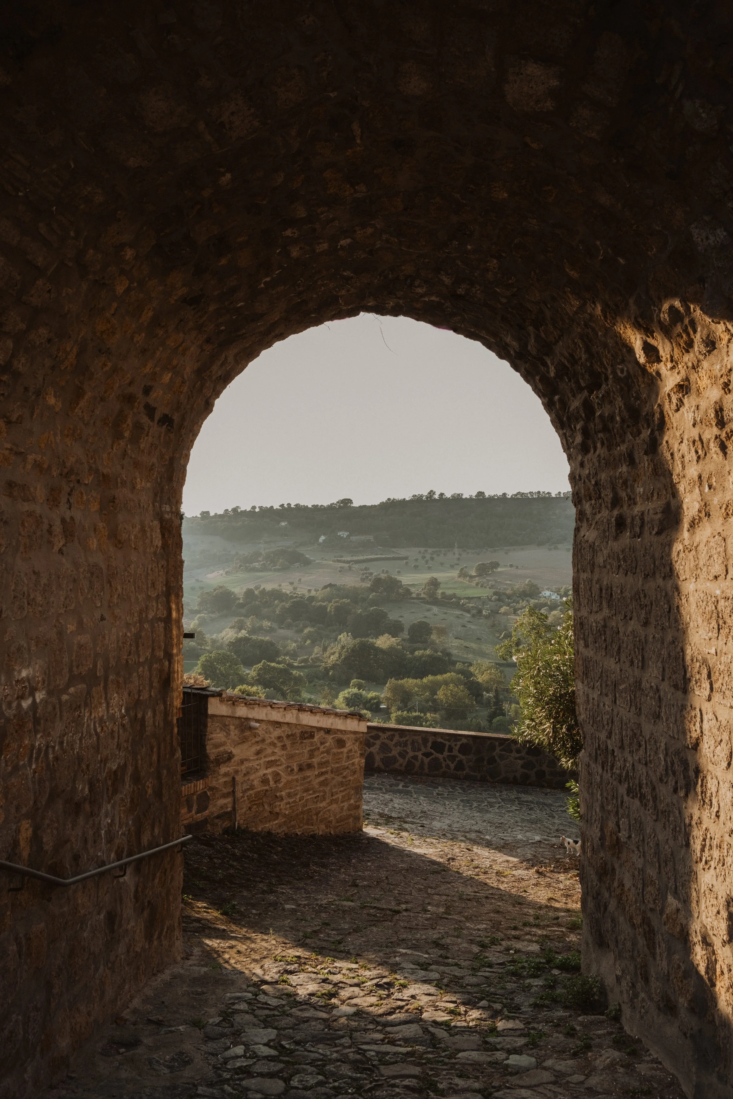 Stone archway overlooking the Italian countryside, a scenic setting for an intimate and elegant destination wedding in Italy.

