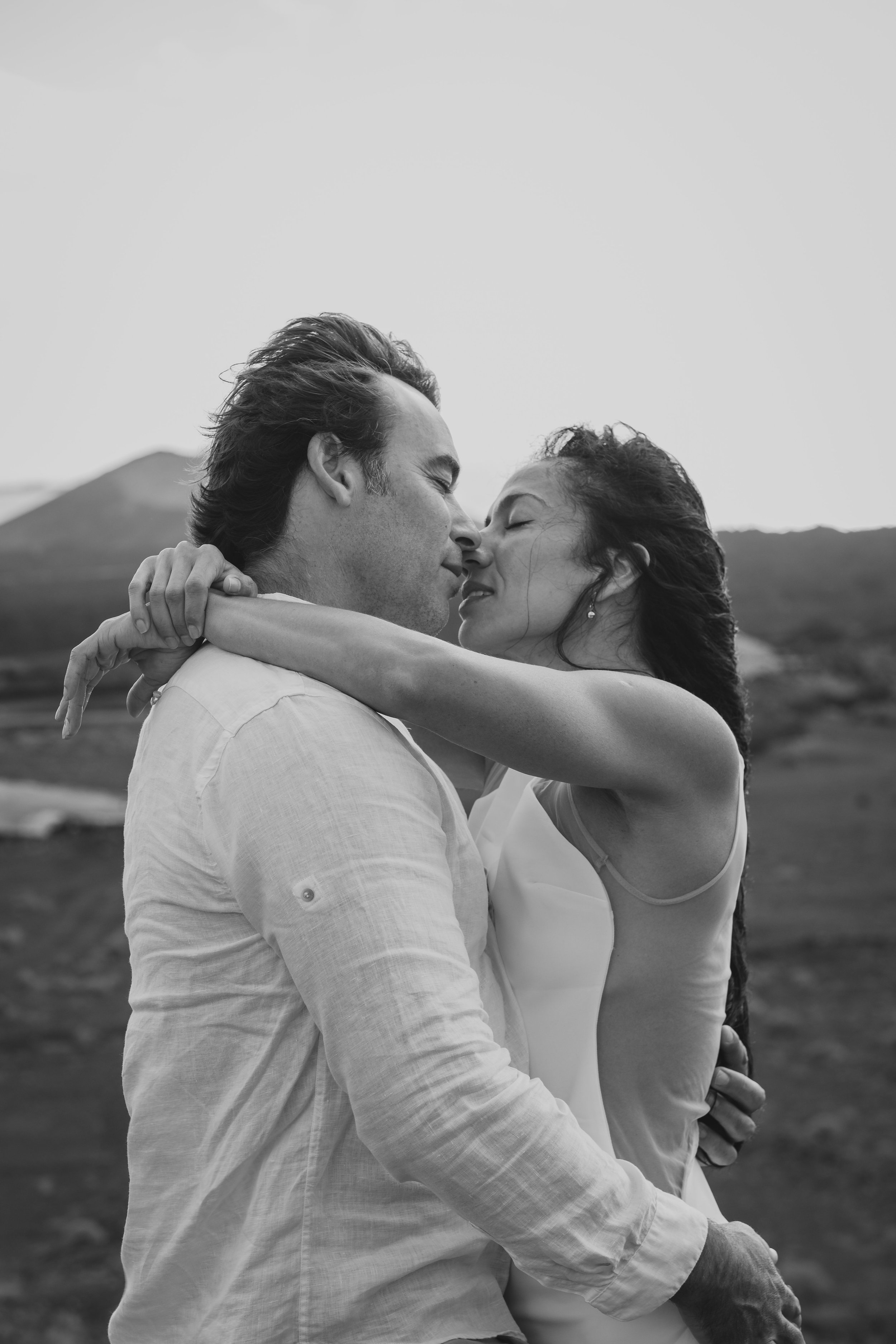 Romantic Couple Embracing on a Windswept Mountain | Destination Wedding Photography