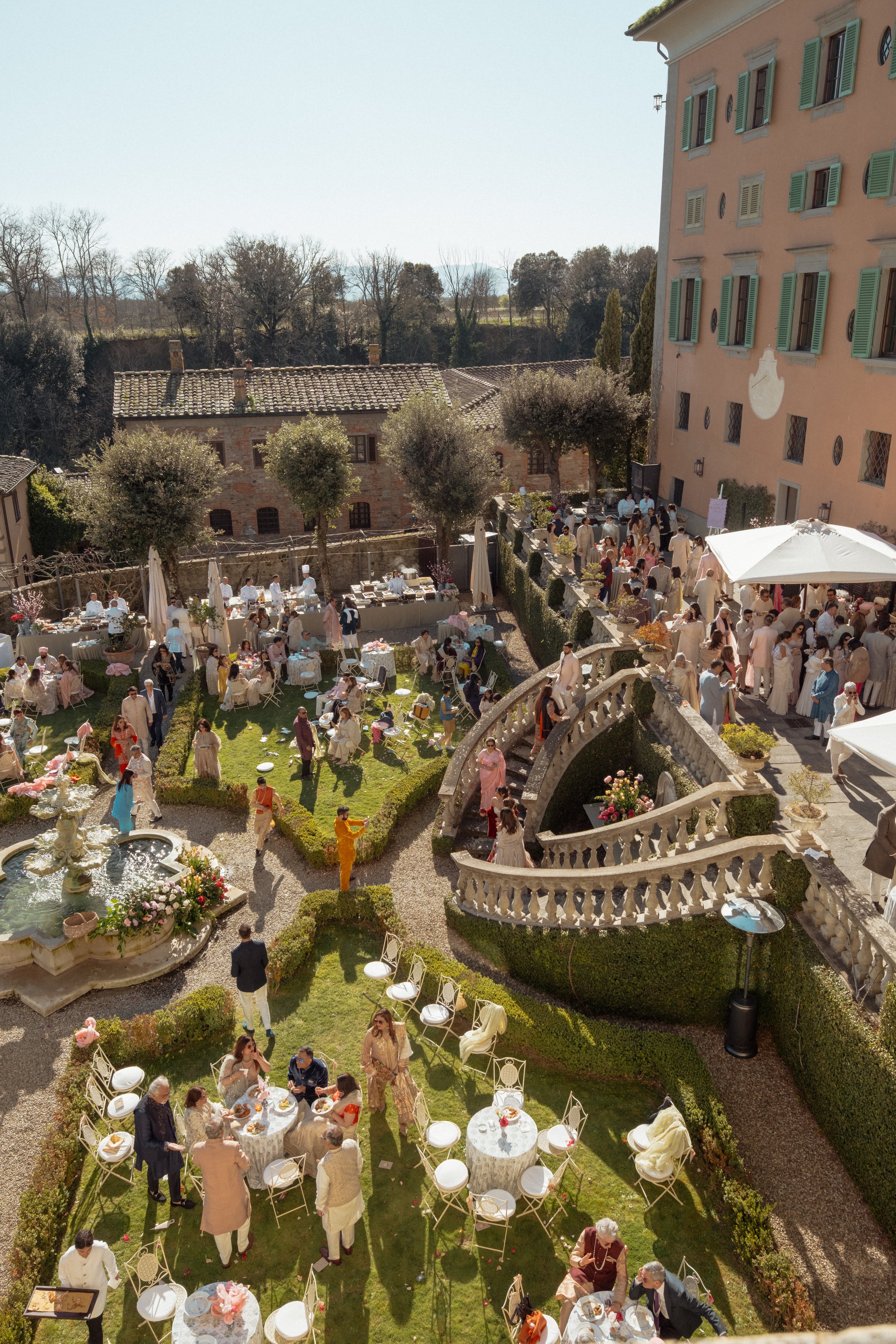 Romantic outdoor wedding dinner setup at Il Borro’s courtyard, with long tables, candles, and guests dining under the Tuscan sky.