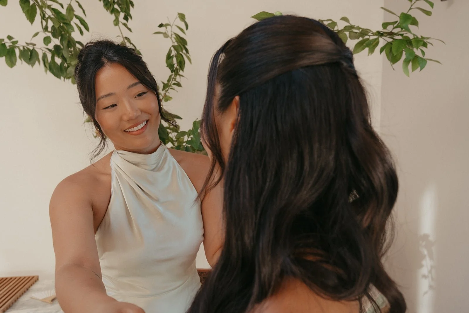 Bridesmaid adjusting bride's dress during getting ready at Villa Lena in Tuscany.