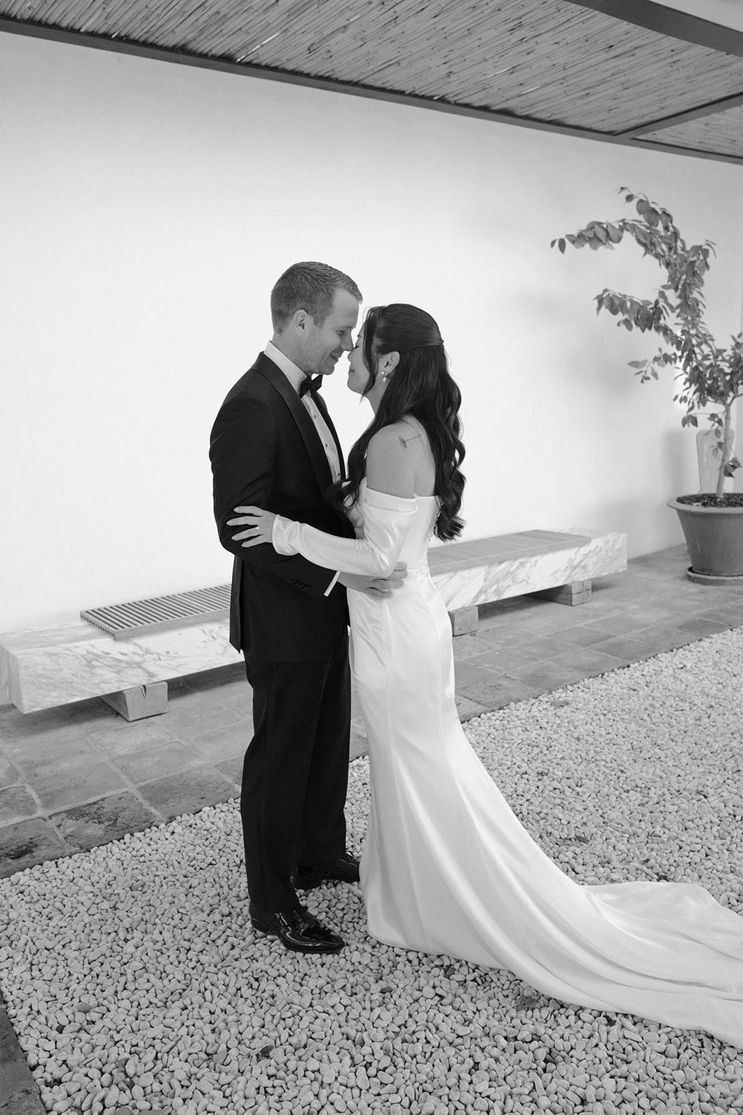 The couple share a quiet embrace before the ceremony, photographed inside Villa Lena with clean lines, neutral tones, and a relaxed atmosphere.