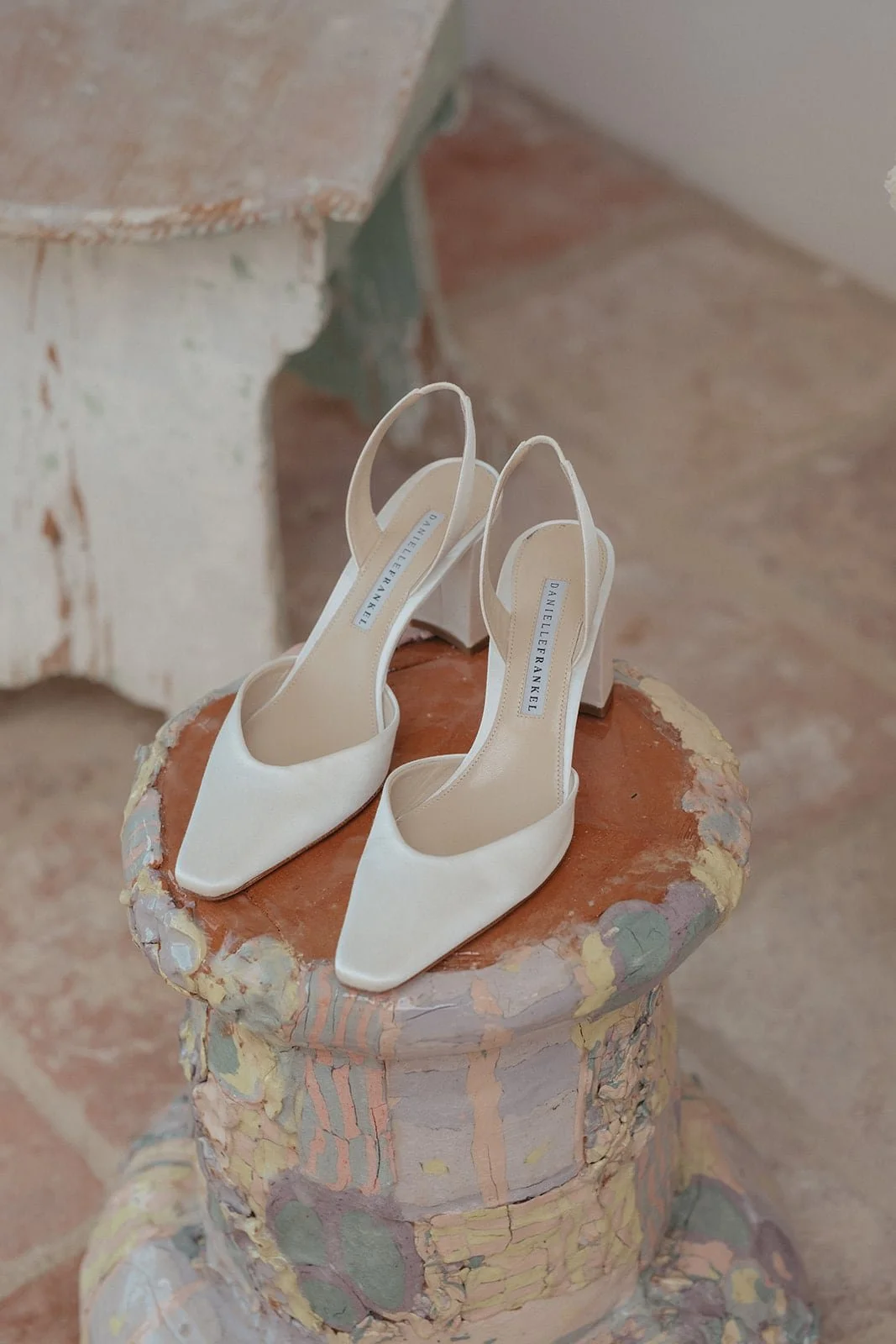 Minimal bridal shoes photographed on textured stone at Villa Lena, blending fashion and Italian character.