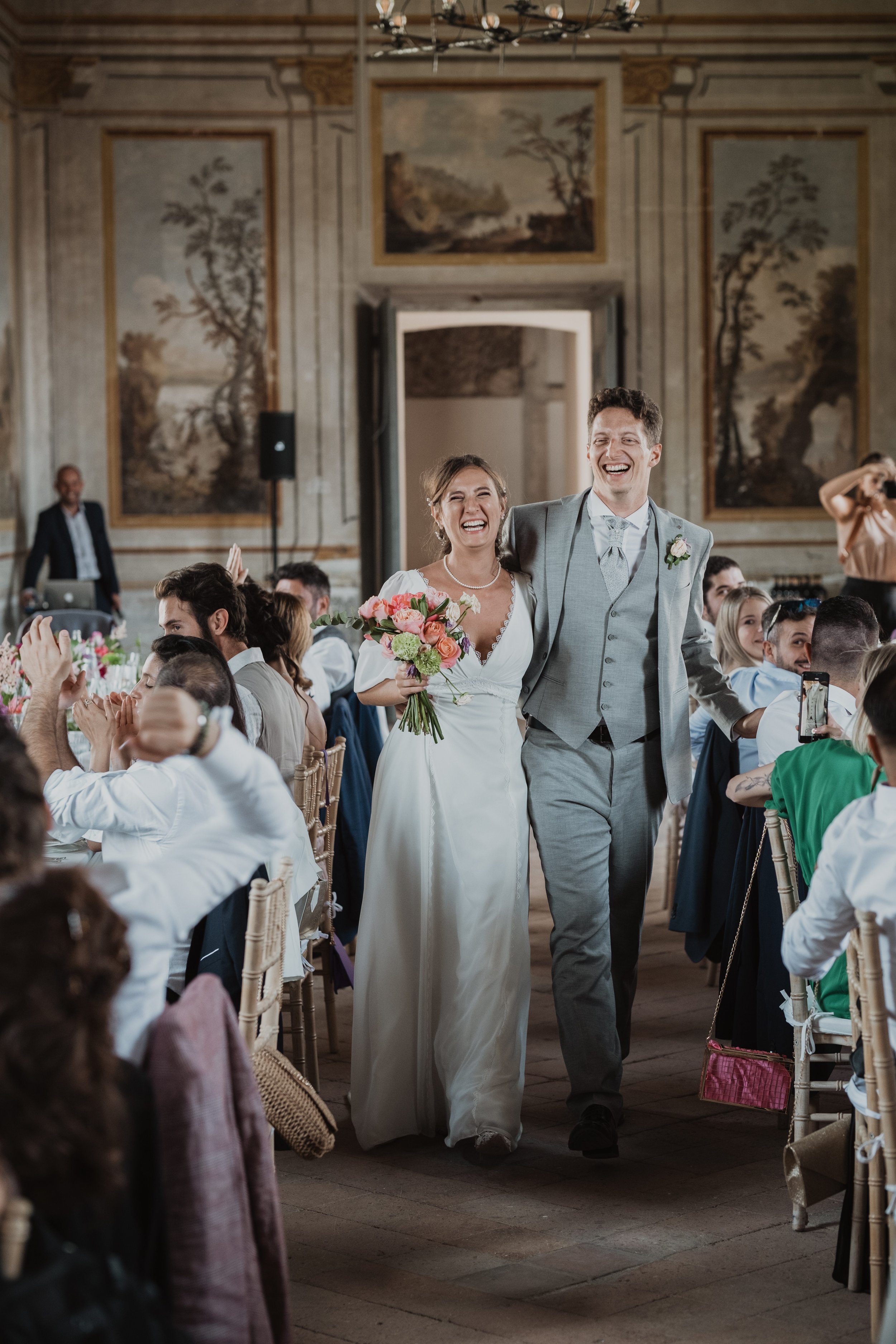Joyful Bride and Groom Walking Down the Aisle at Wedding Reception | Luxury Wedding Photography in Tuscany