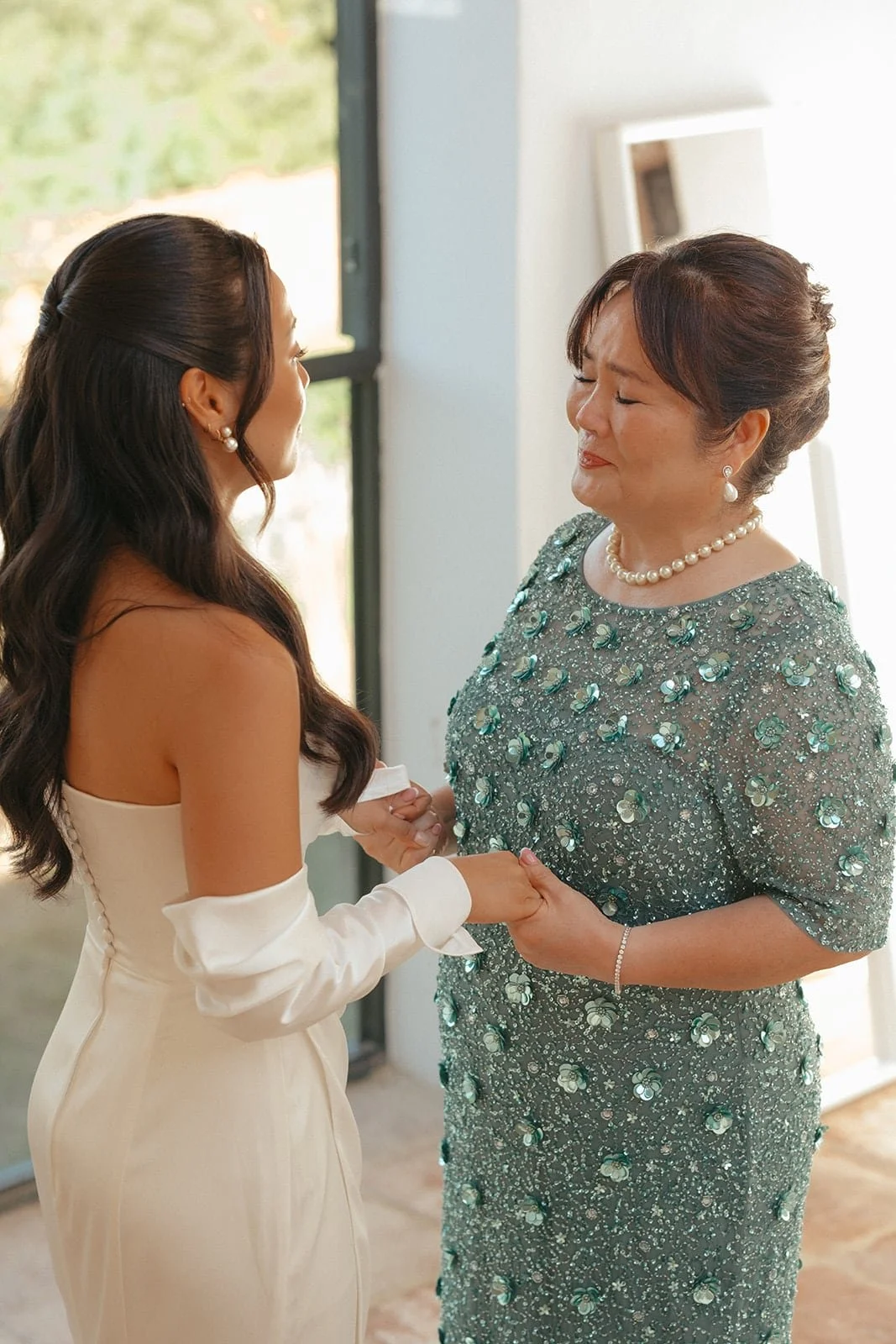 An emotional moment between the bride and her mother as they hold hands before the ceremony in Tuscany.