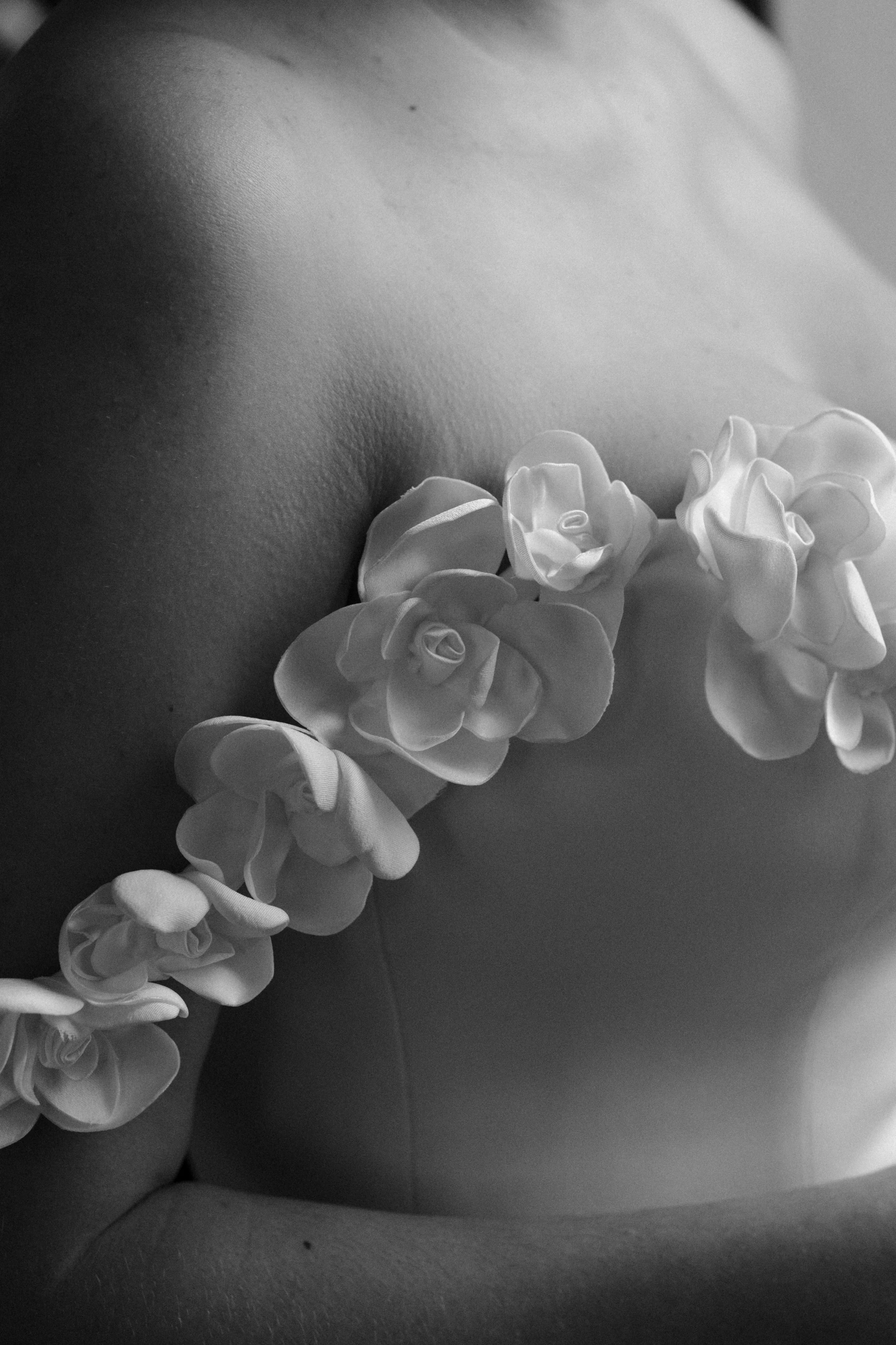 A close-up of a couture wedding dress detail, photographed in black and white to highlight texture, craftsmanship, and timeless bridal elegance.