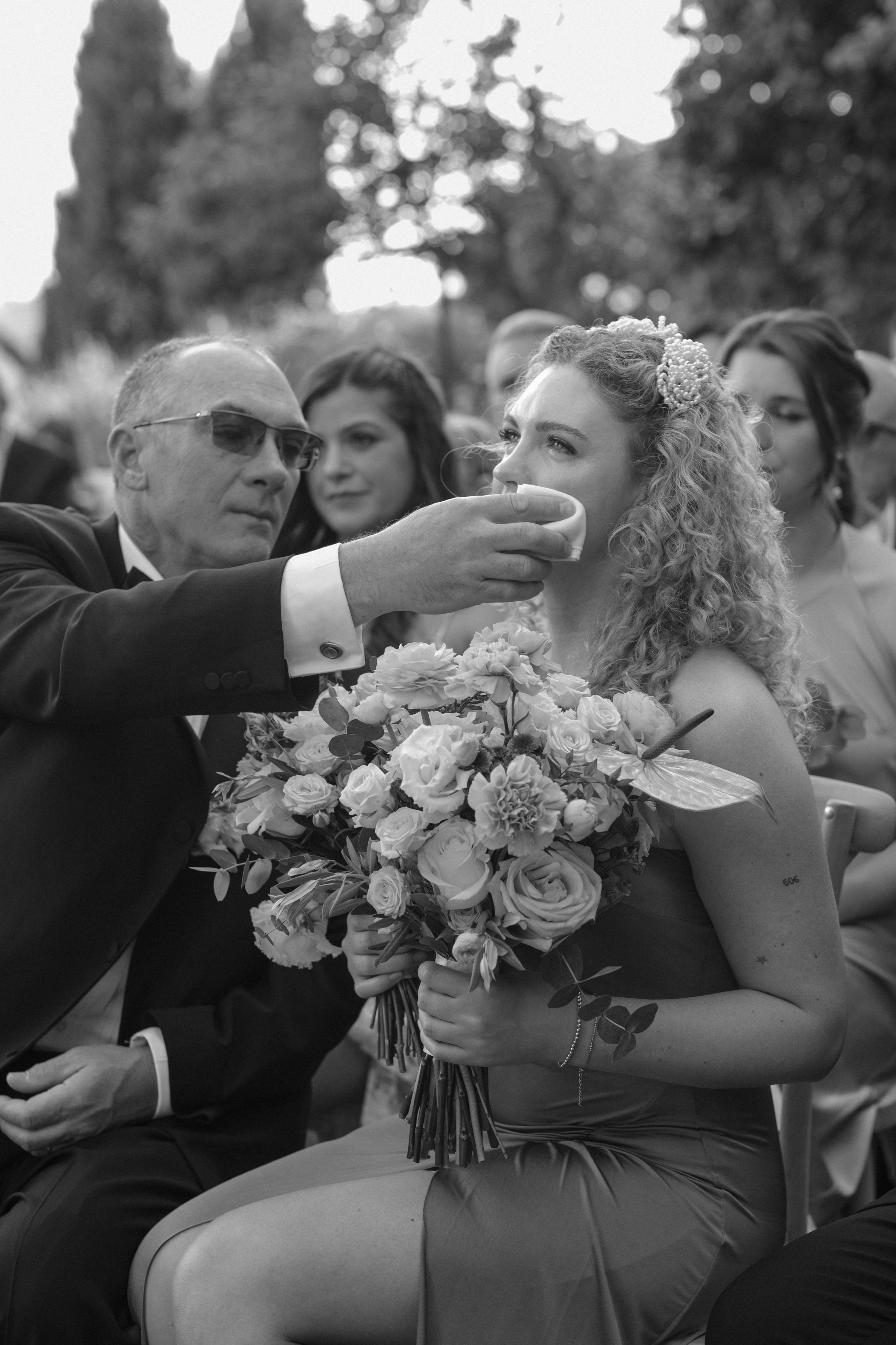 Father Helping Bride’s Guest with a Sip at Castello di Bibbione | Intimate Wedding Moment | Luxury Wedding Photography