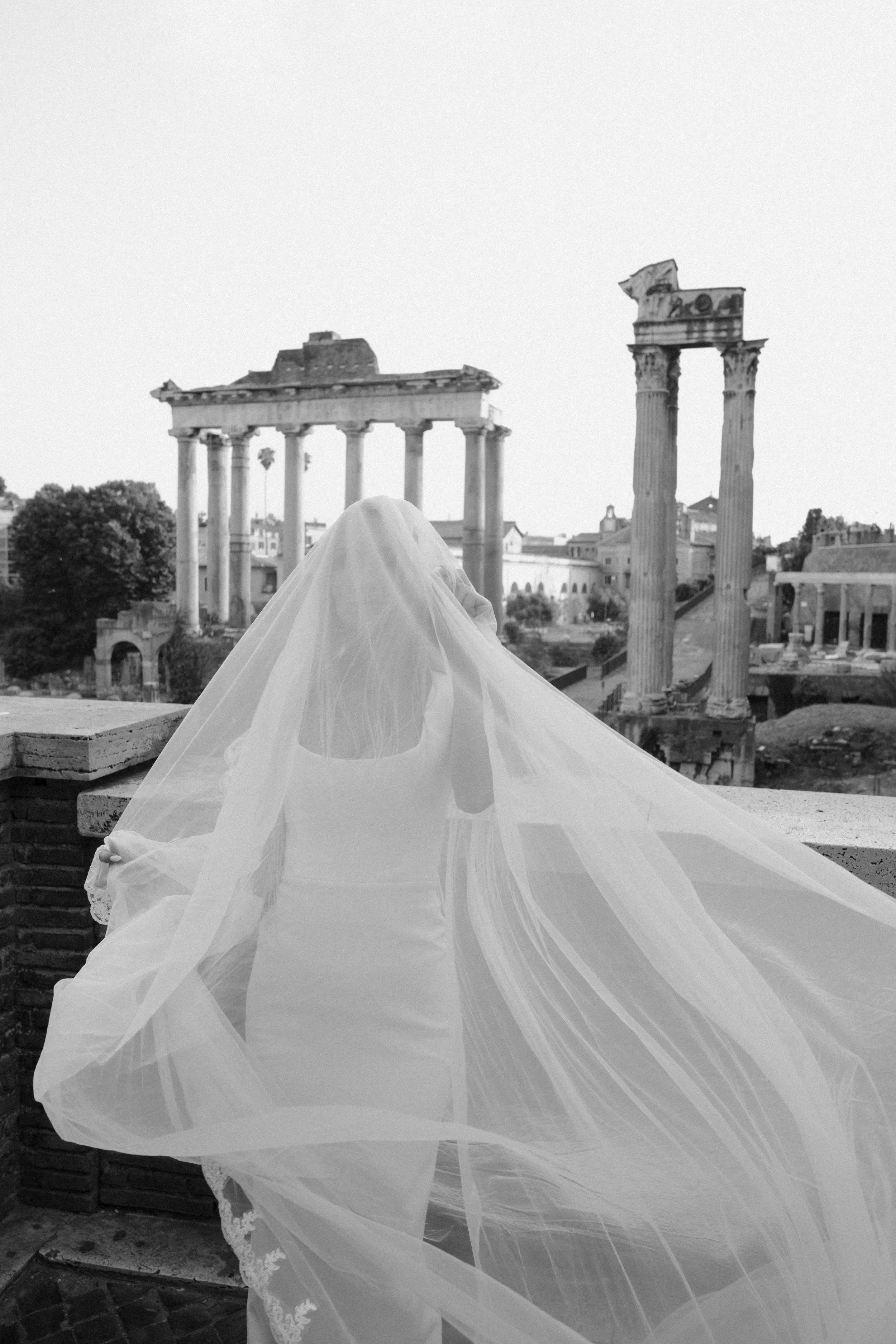 An editorial bridal portrait overlooking the Roman Forum, capturing timeless elegance and the atmosphere of a refined luxury wedding in Rome.