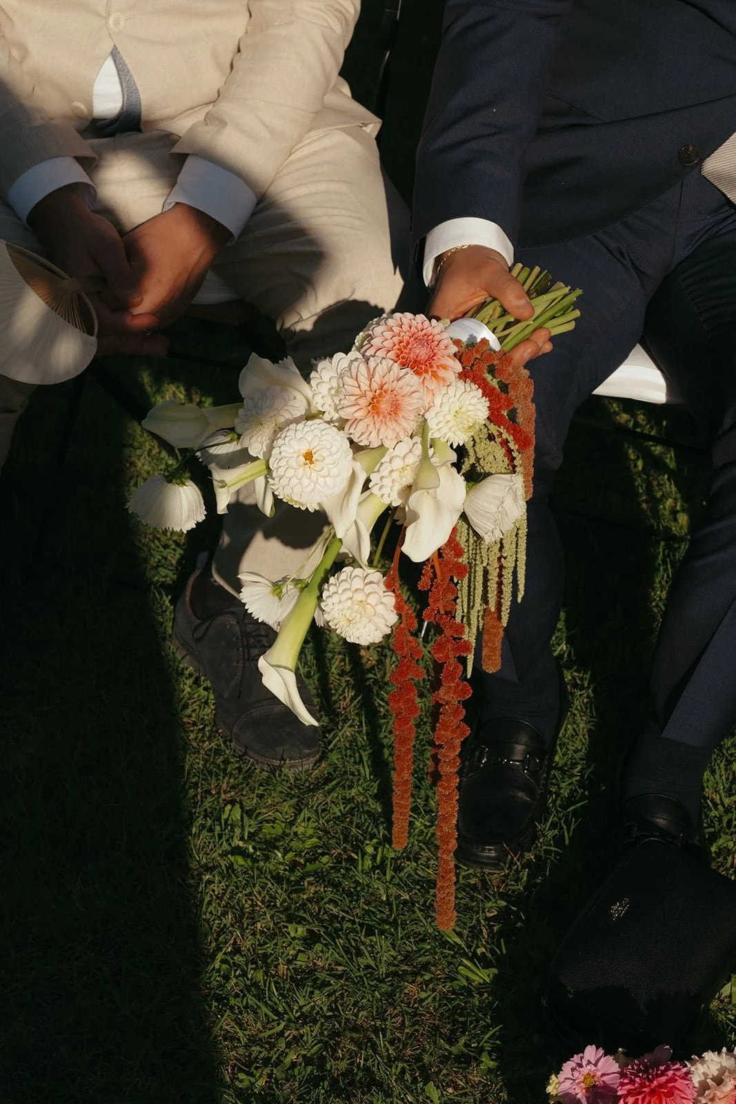 A close detail of ceremony flowers resting in a guest’s hands, photographed in natural light during the outdoor wedding in Tuscany.