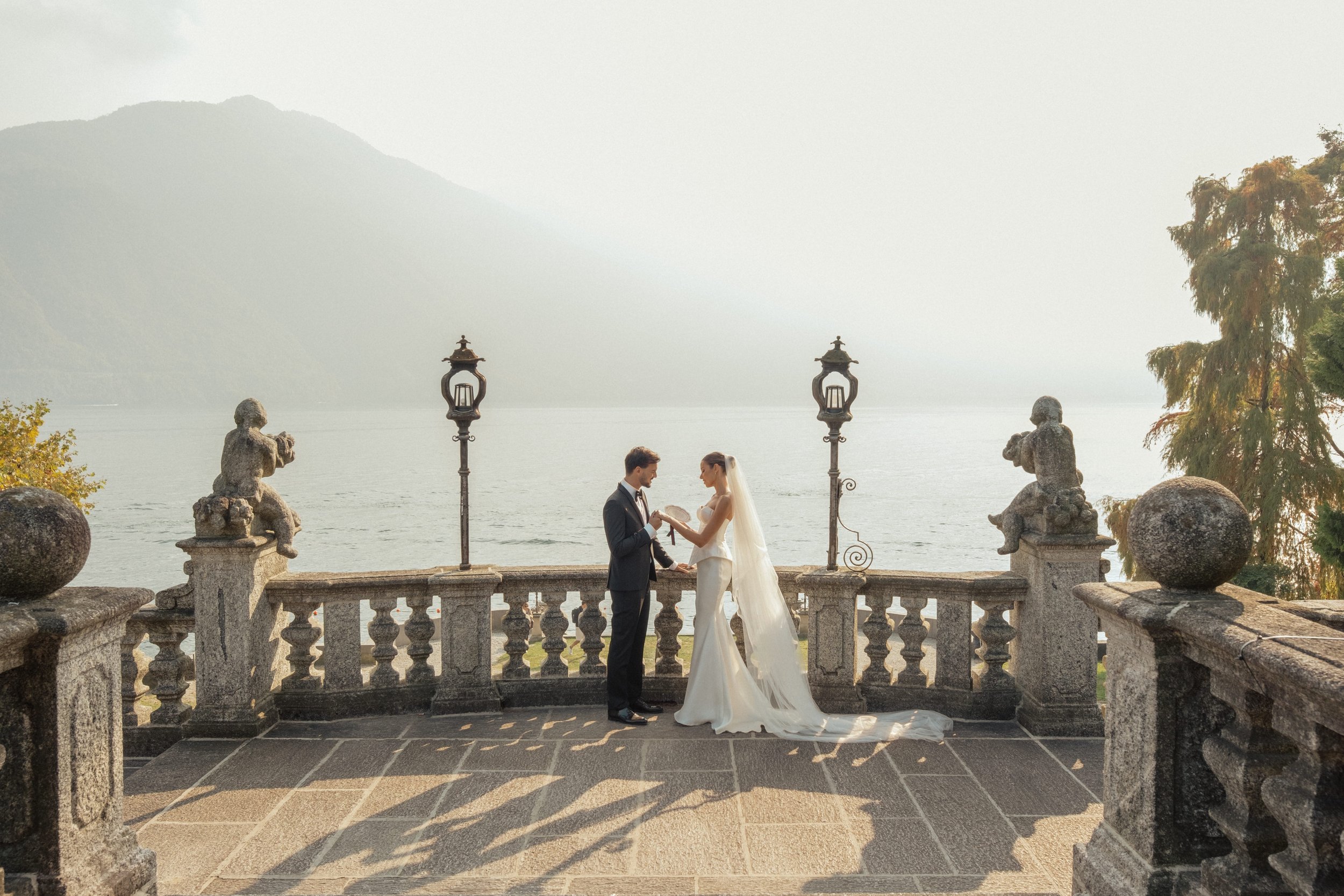 Bride and groom exchanging vows on a historic villa terrace overlooking Lake Como, Italy.