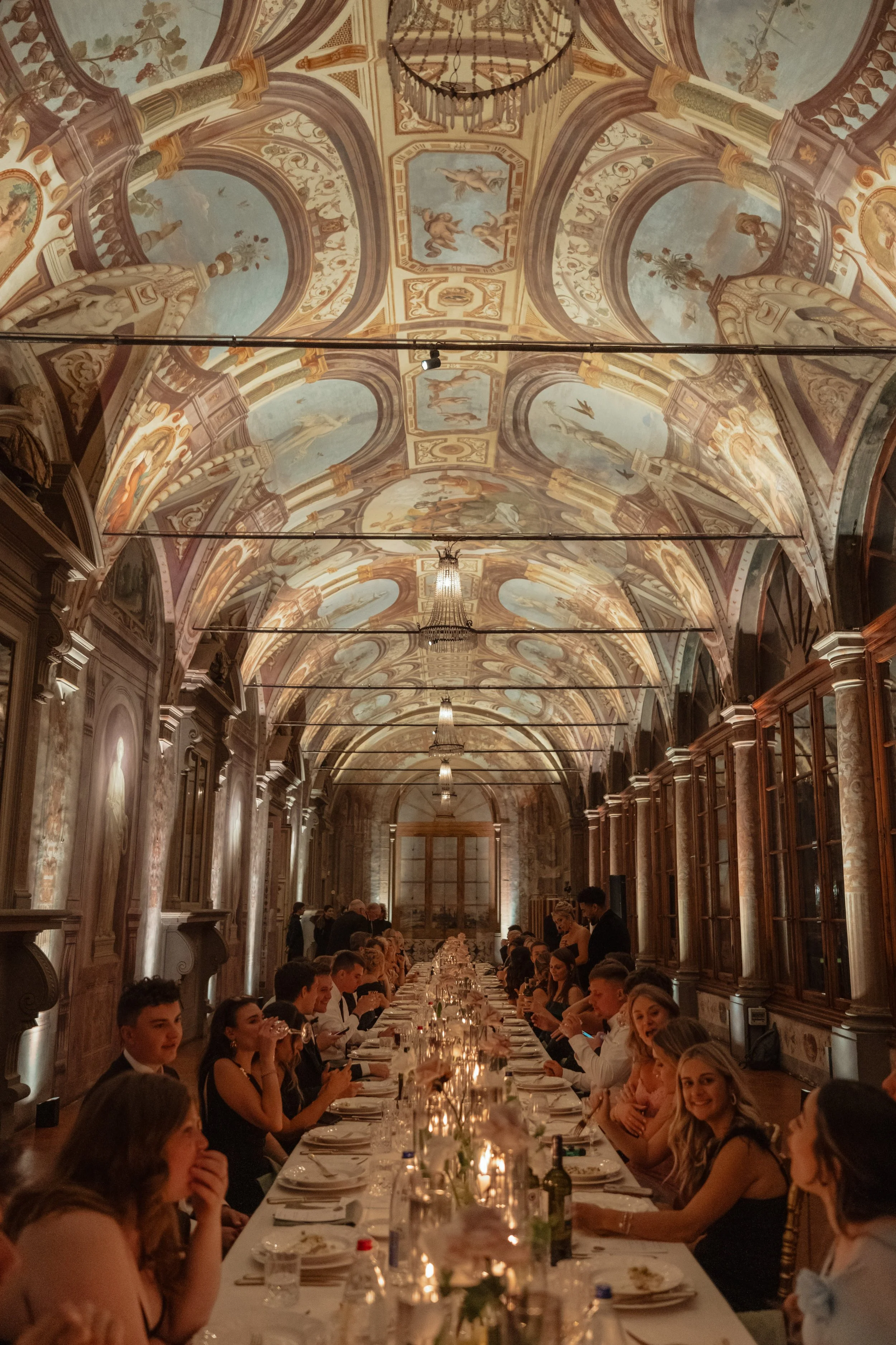 An elegant evening wedding reception at Villa Corsini in Florence, set beneath a frescoed ceiling and captured with an editorial, atmospheric style.