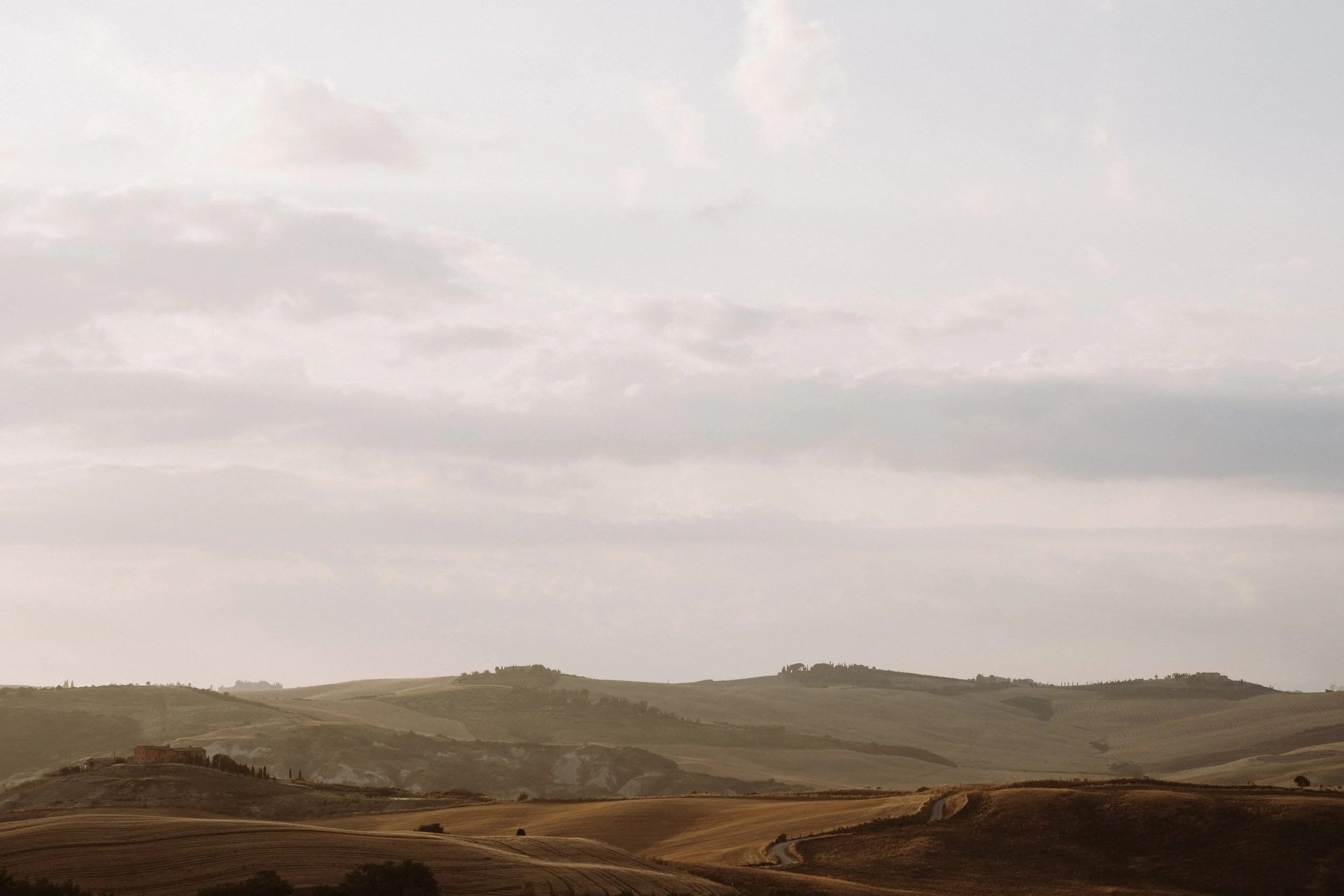**Meta description:**  Soft evening light over the rolling hills of Val d’Orcia, Tuscany, capturing the timeless beauty of the countryside in a calm, atmospheric landscape.