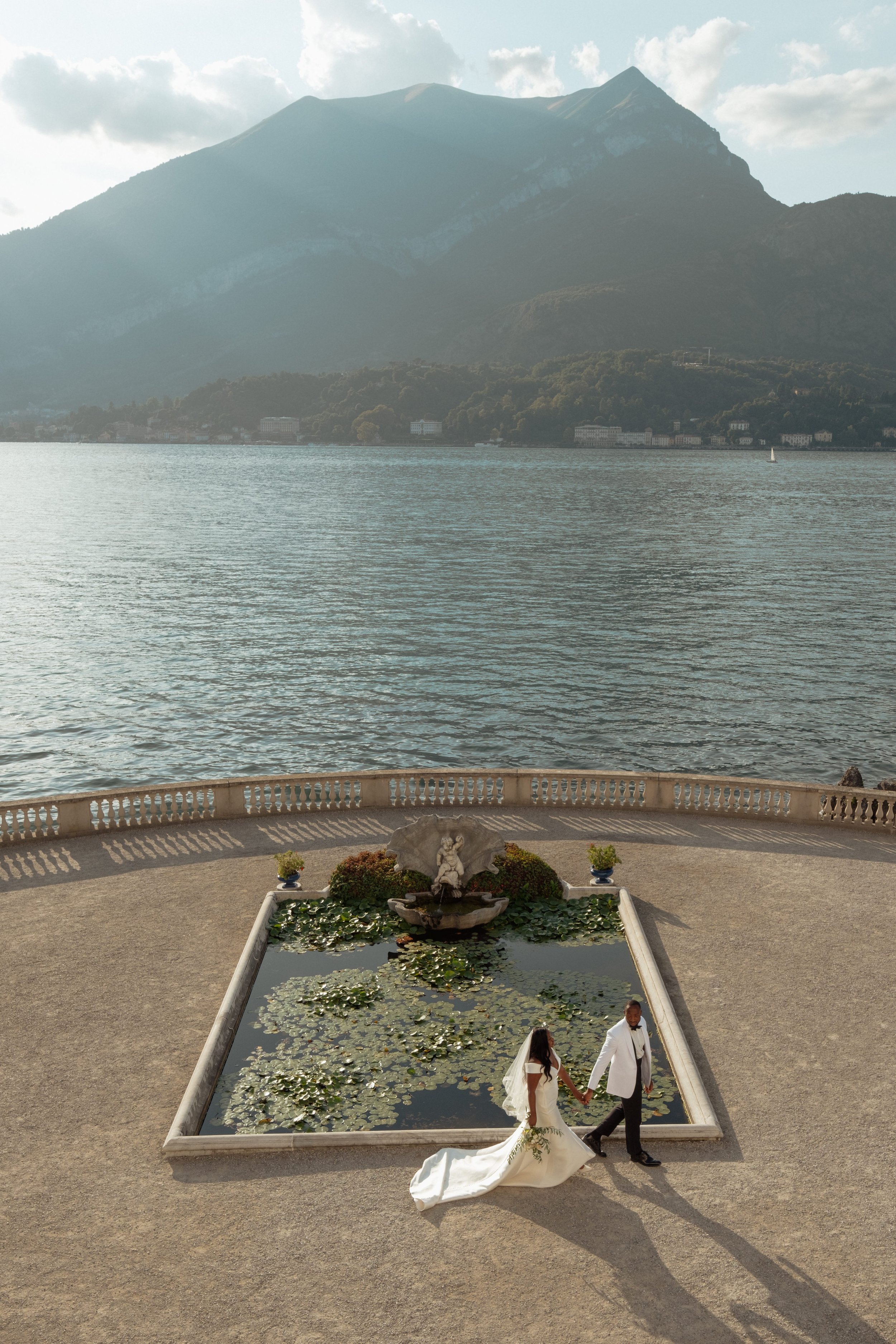 Couple Walking by the Fountain on Lake Como at Giardini di Villa Melzi| Luxury Destination Wedding Photography