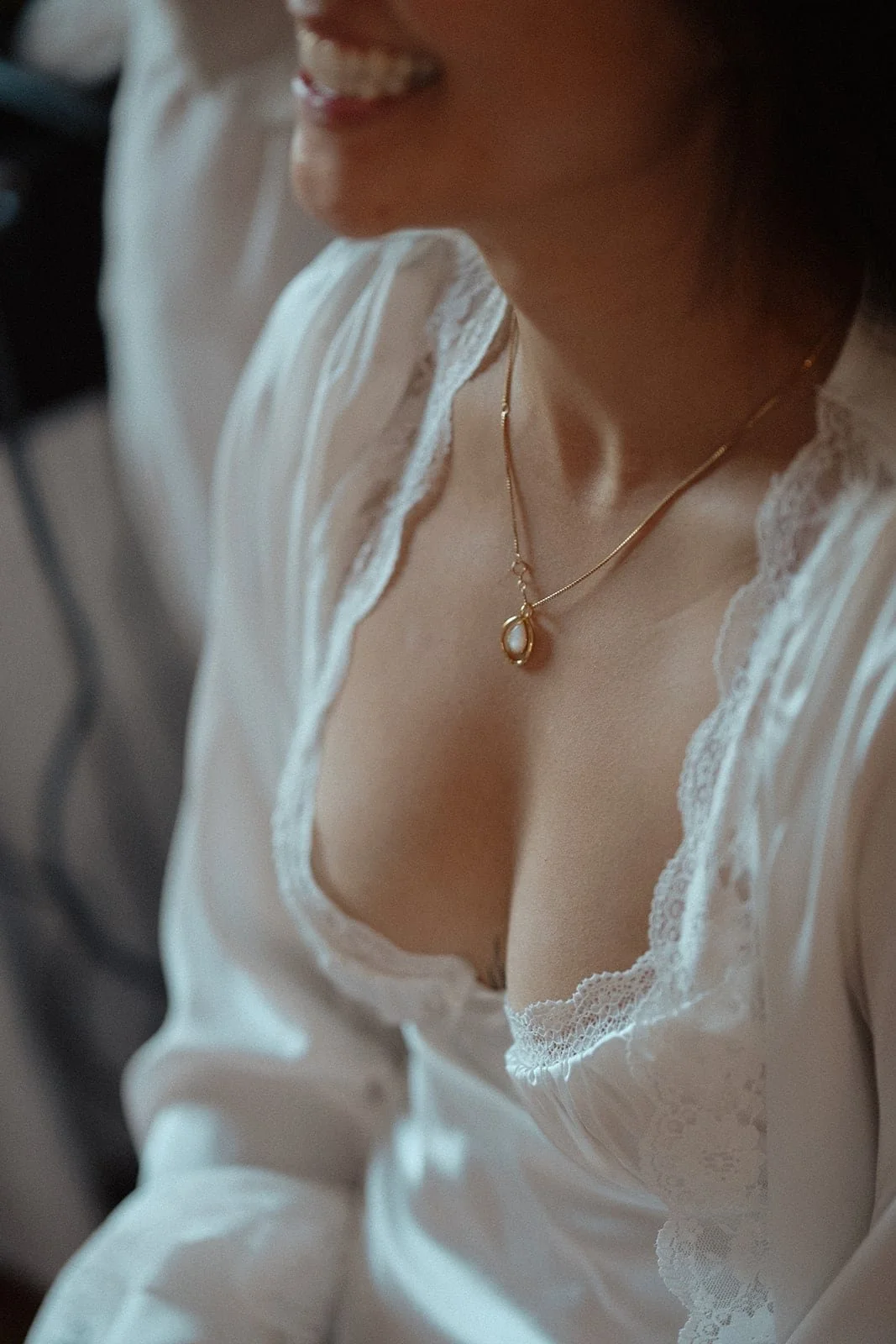 The bride shares a quiet smile as a bridesmaid helps her into her dress, surrounded by soft light inside a modern Tuscan villa.
