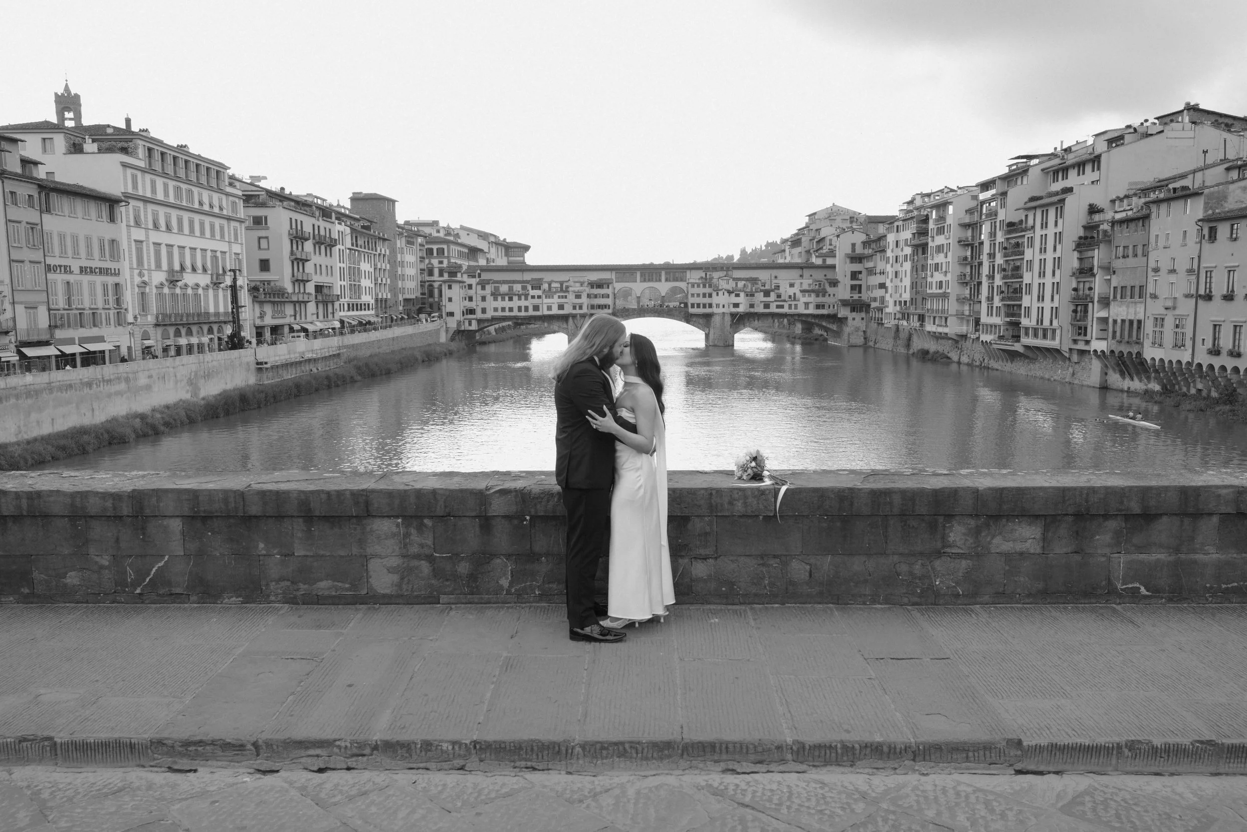 A romantic Florence elopement on Ponte Vecchio, captured in timeless black and white with the Arno River and historic cityscape as a cinematic backdrop.