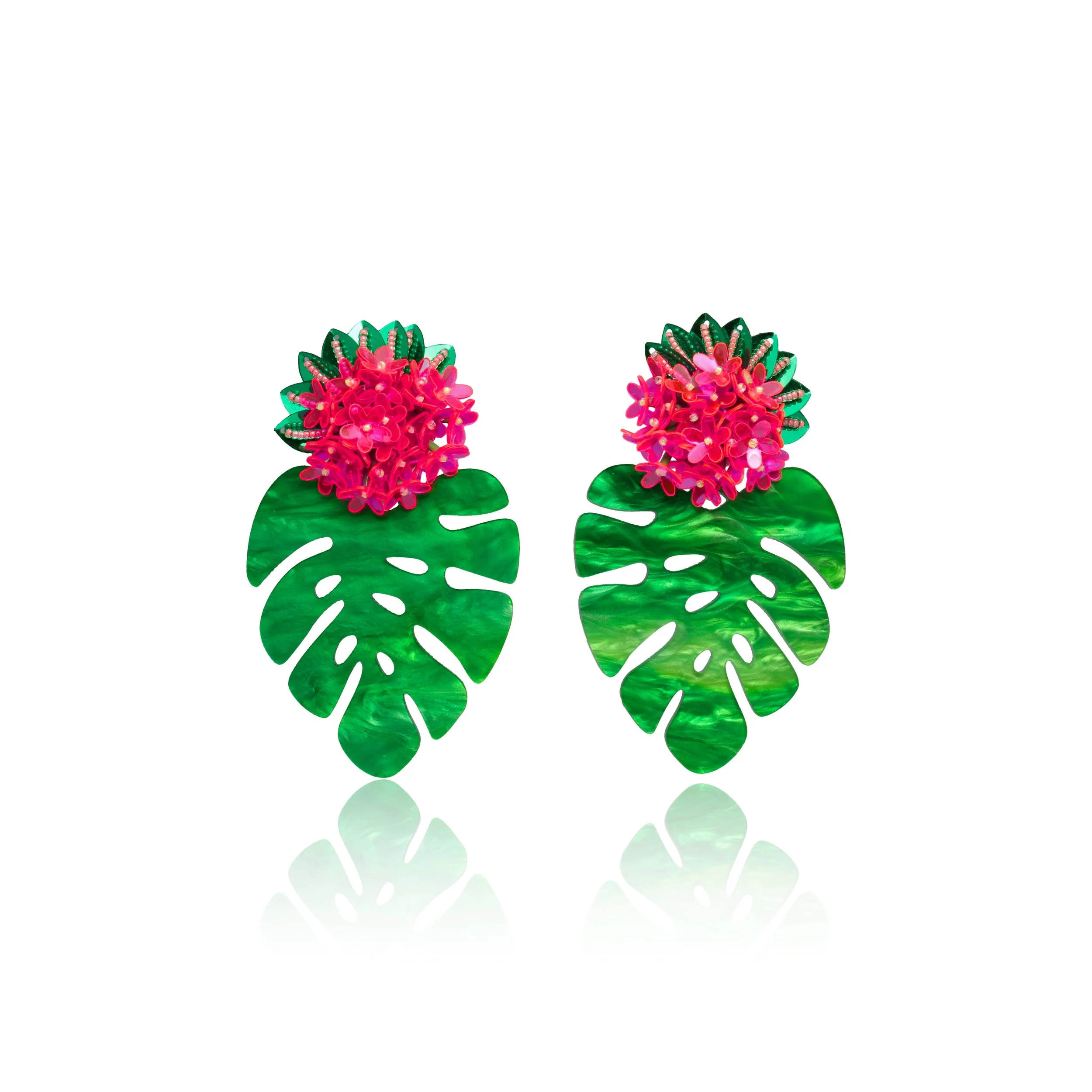 Pair of earrings with pink flowers and green monstera leaf design on a white background.