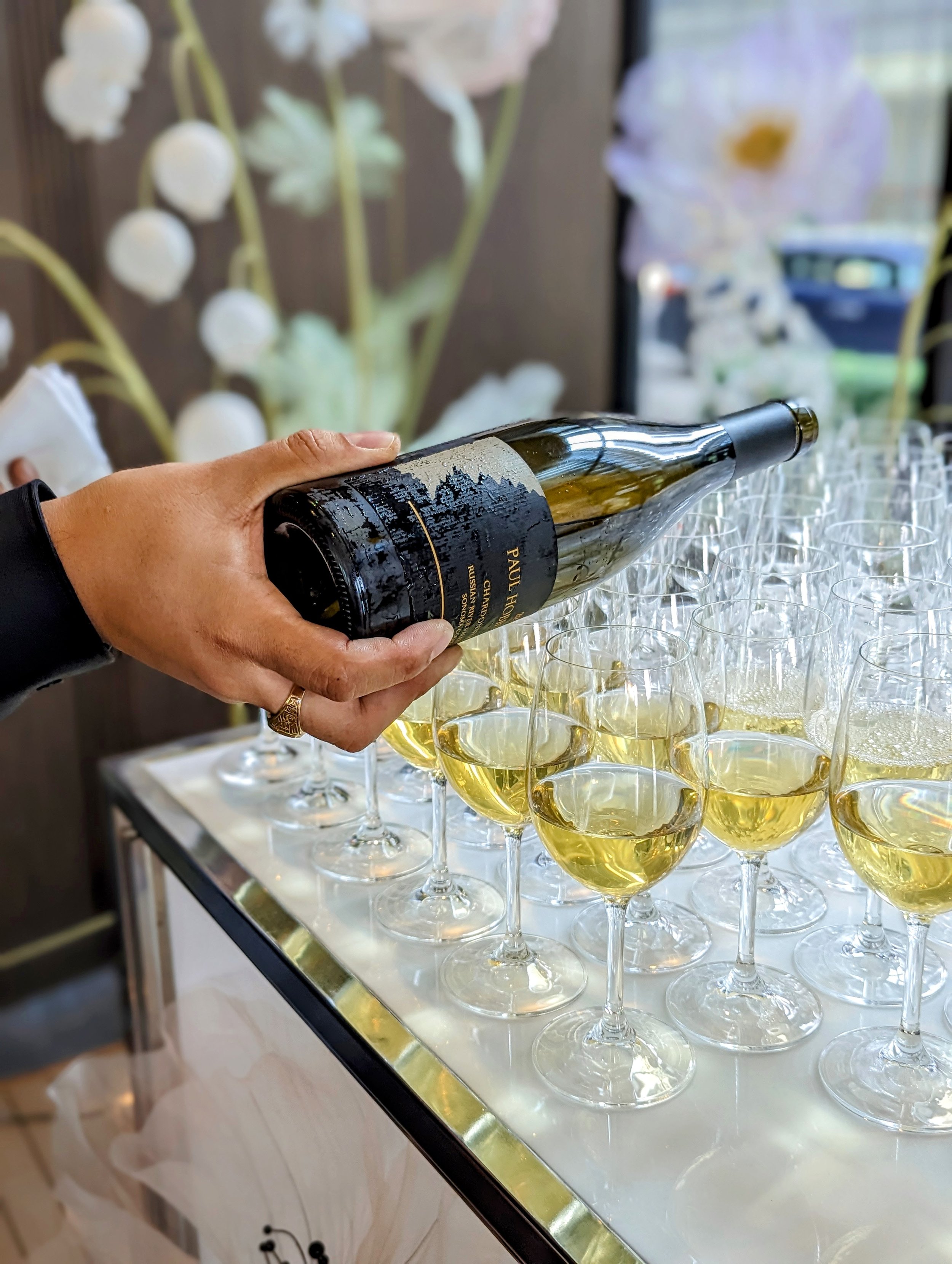 Male sommelier pouring glasses of chardonnay for a wine seminar