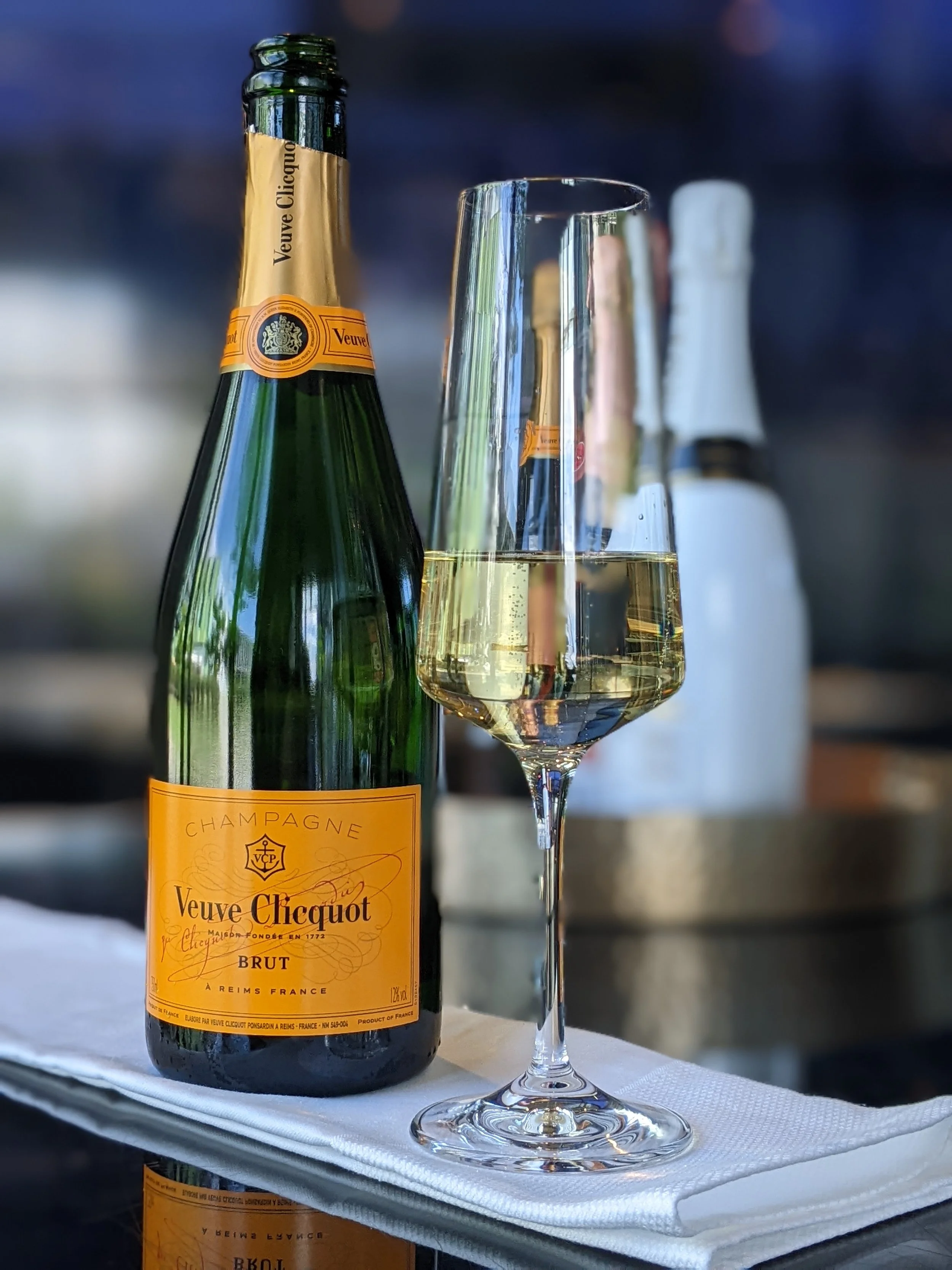 Veuve Cliquot champagne bottle and glass of champagne at a private tasting event