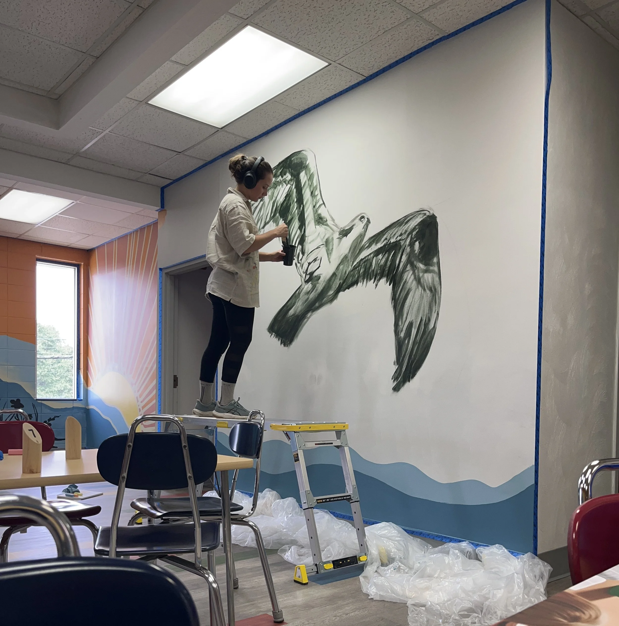 Carrie Lane in the middle of painting a mural for Kings Kids Youth Development Center, 2025.