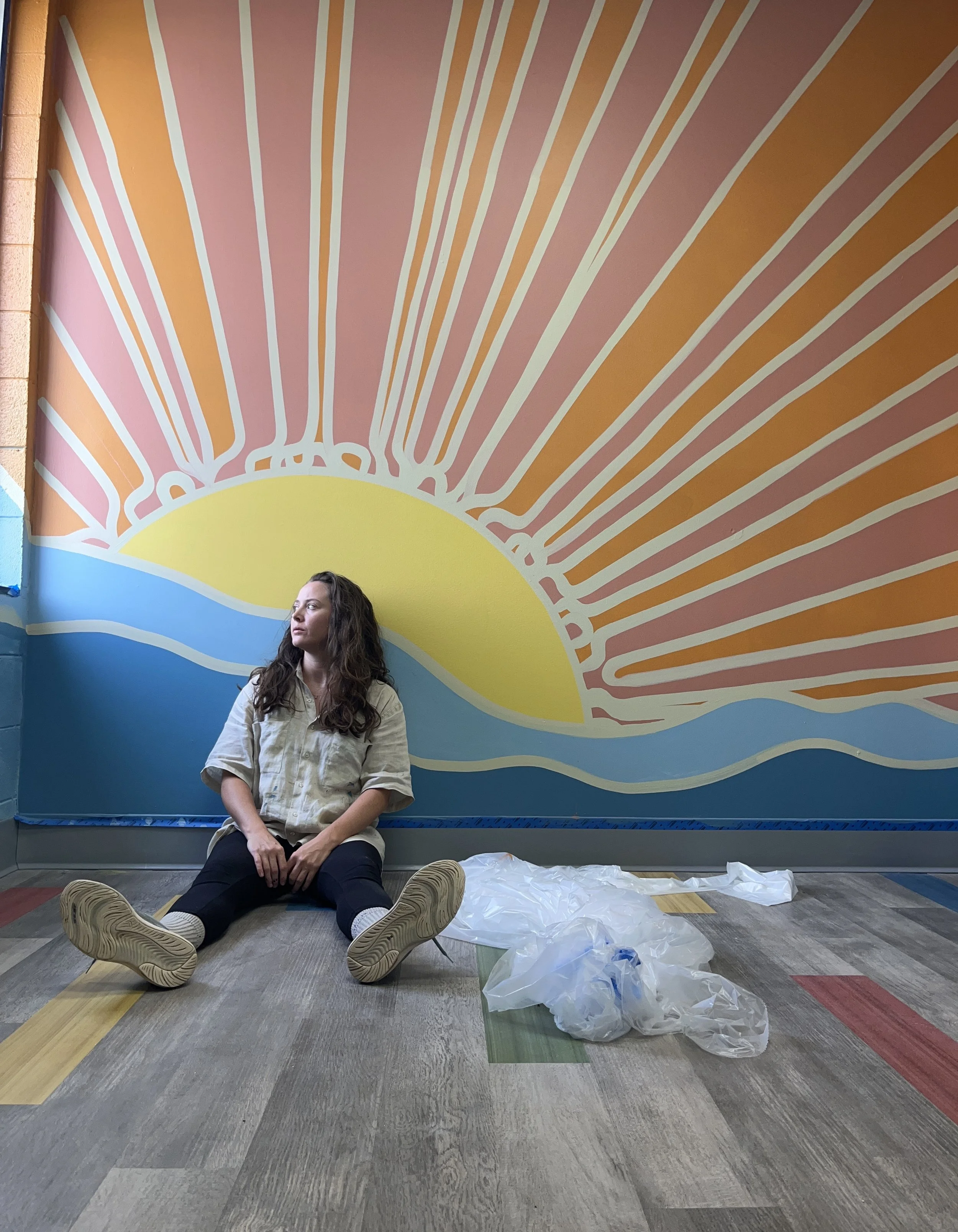 Carrie Lane rests after completion of mural for The Kings Kids Youth Development Center in Norfolk, VA, USA.