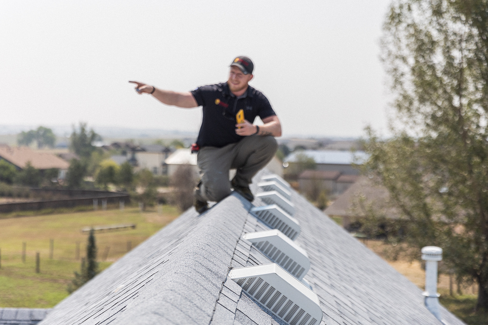 A Pride team member examining a roof ridge and pointing out a detail