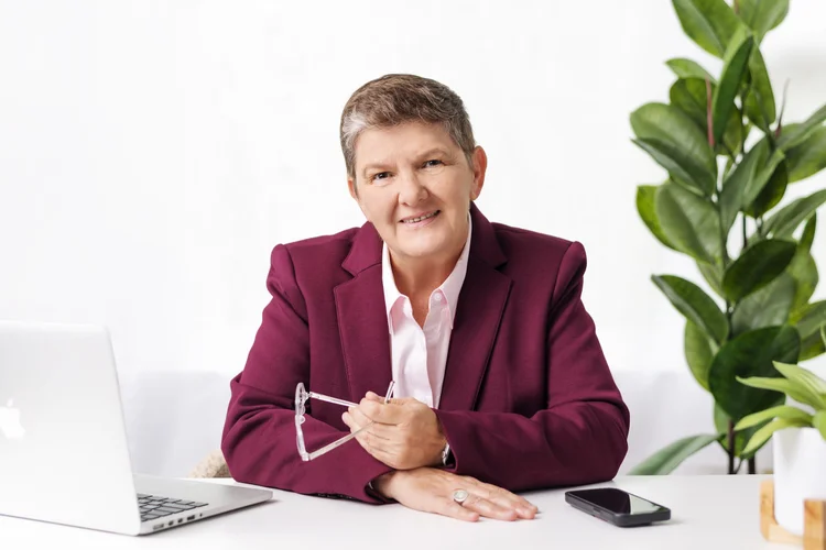 Toni Bator, smiling, in a burgundy blazer