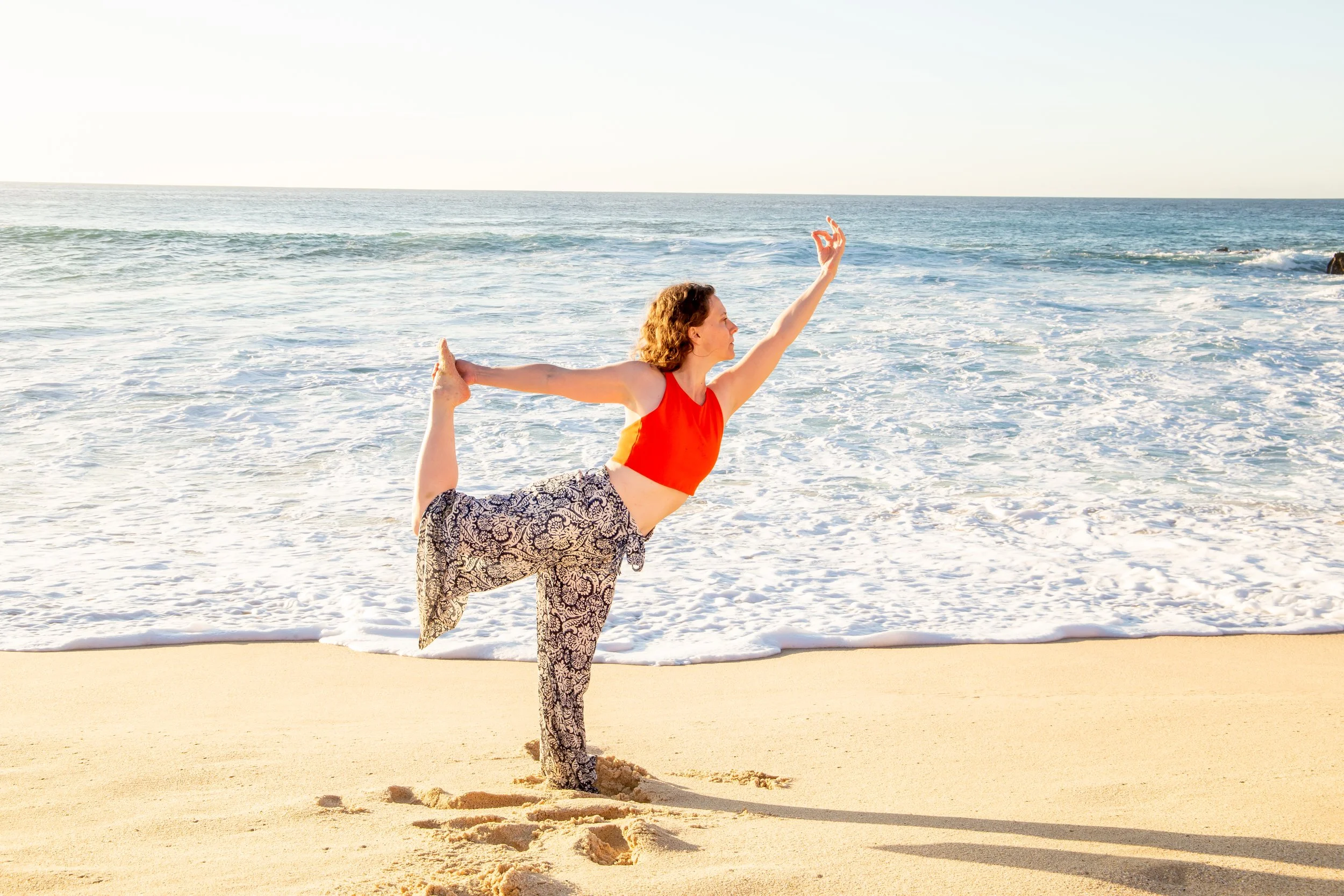 Sarah Anne does a balance pose, dancer, in front of the ocean