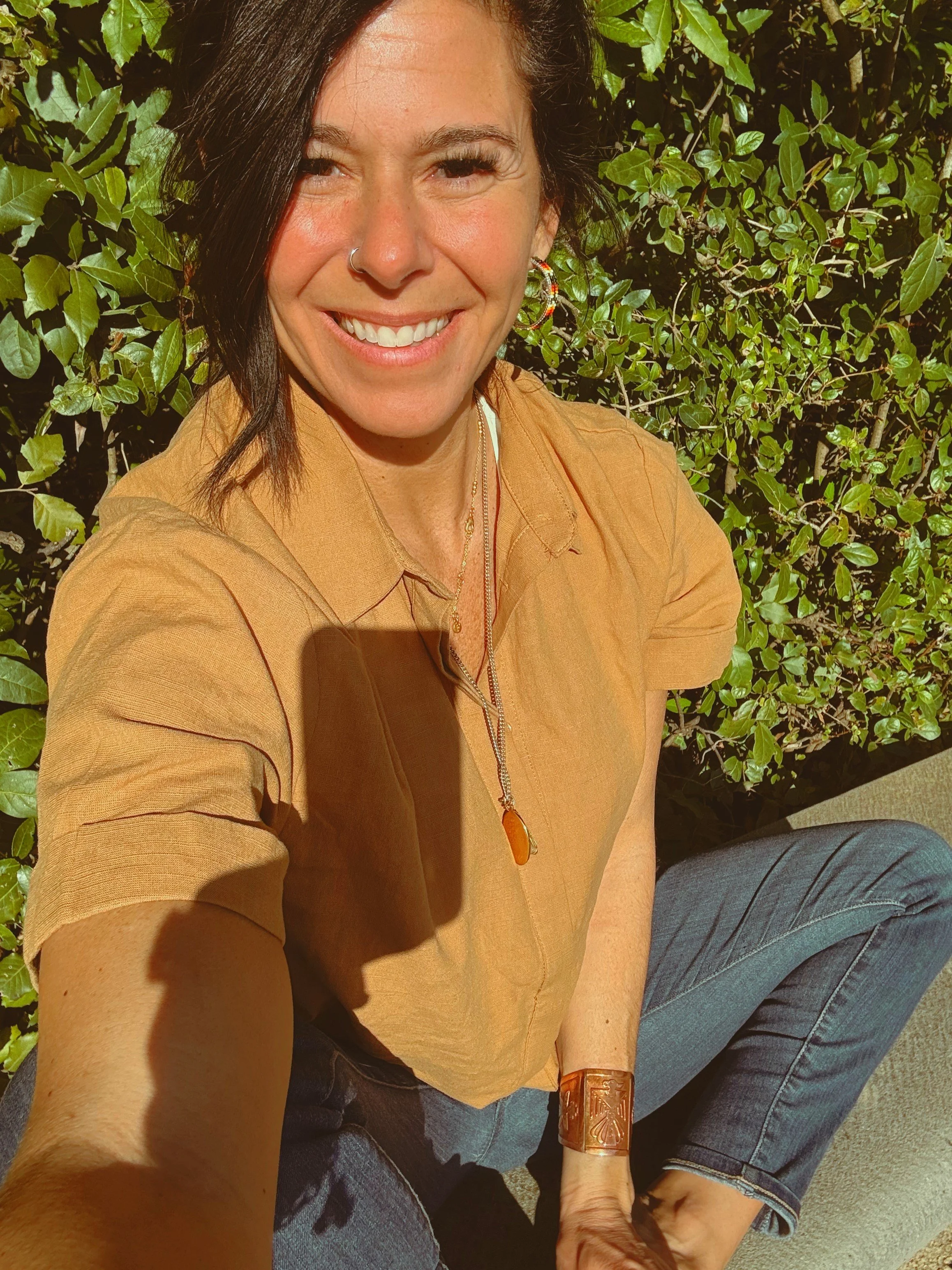 Kristina smiling for a picture sitting criss-cross.
