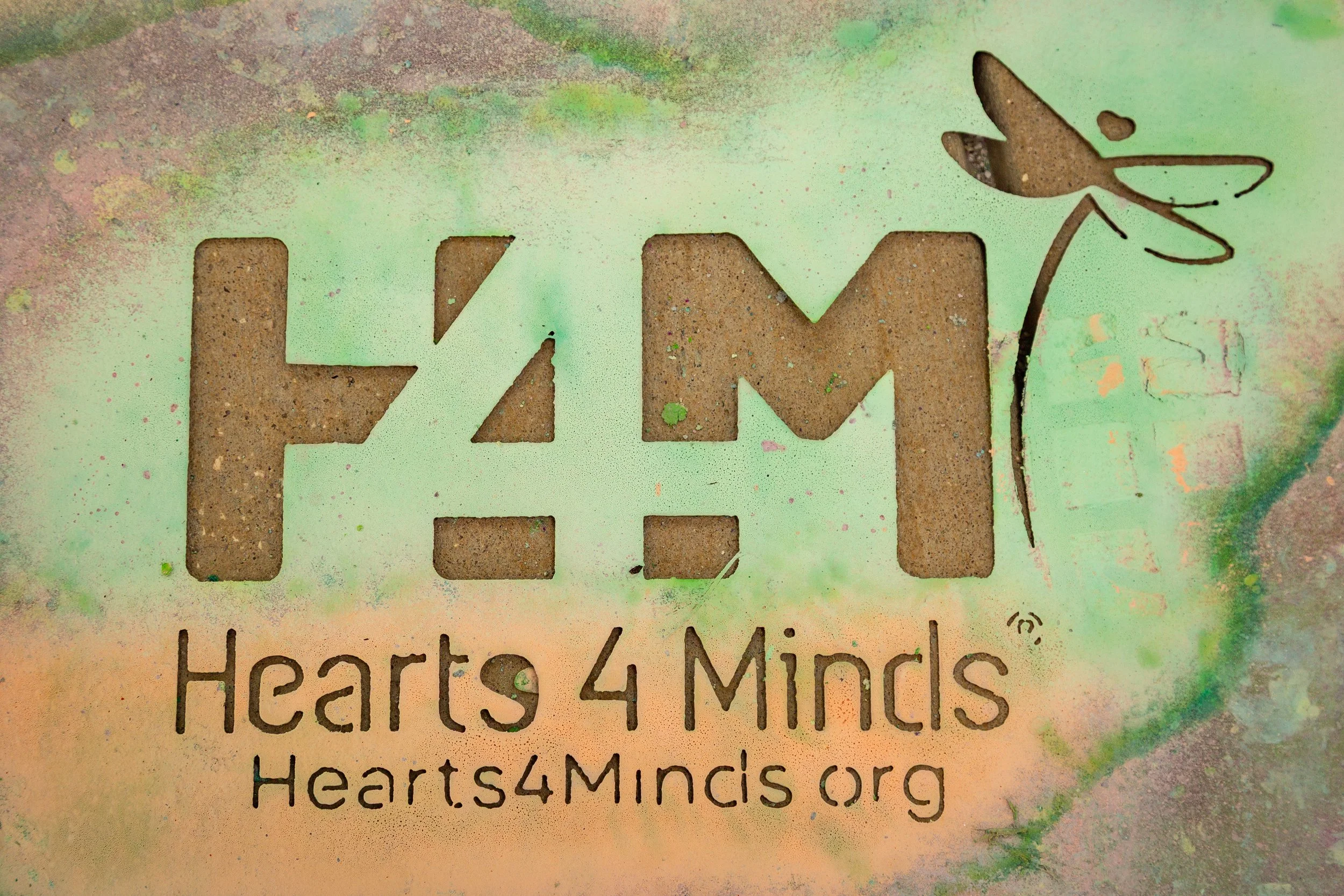 Hearts4Minds stencil that display the website at the bottom and a dragonfly in the corner.