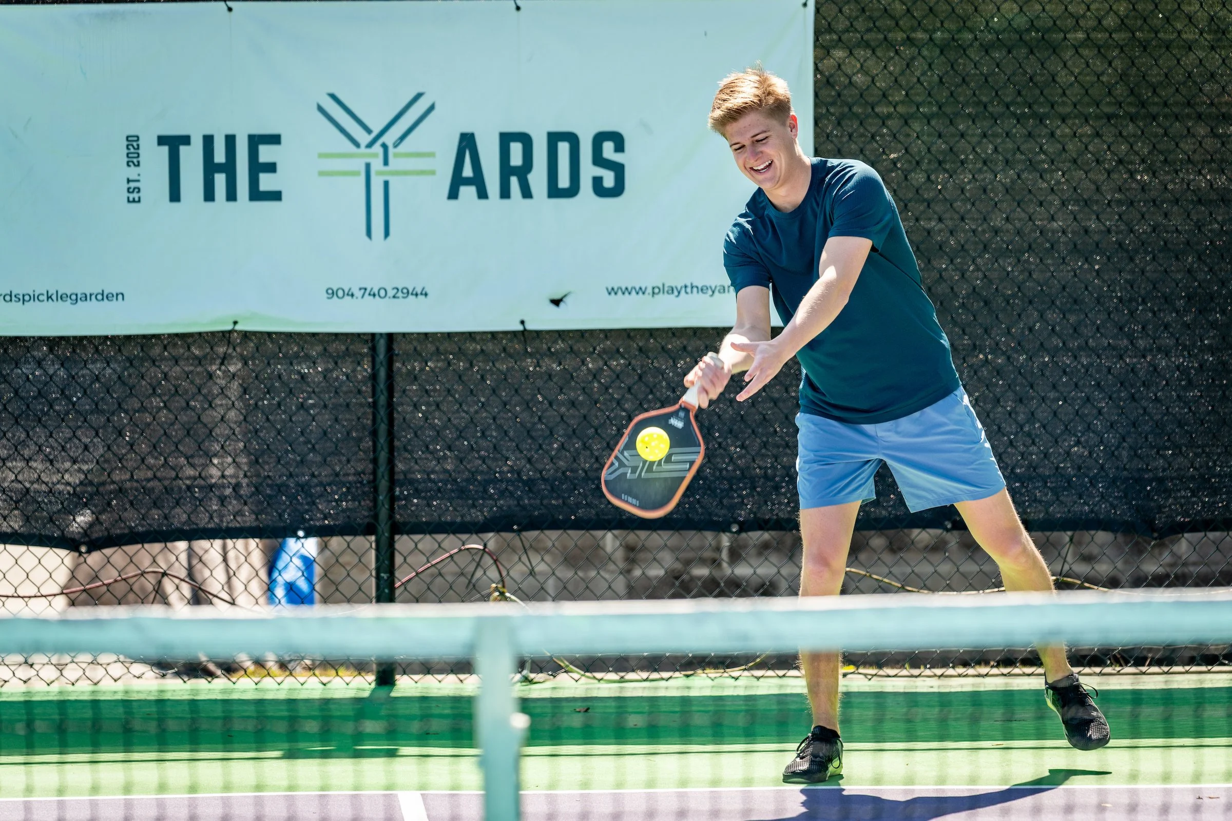 Man playing pickleball on a court at the Yards.