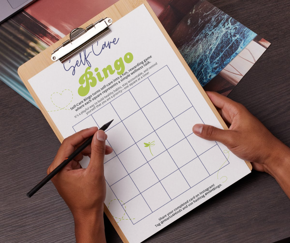 Image of a person holding a clipboard with a bingo sheet on it.