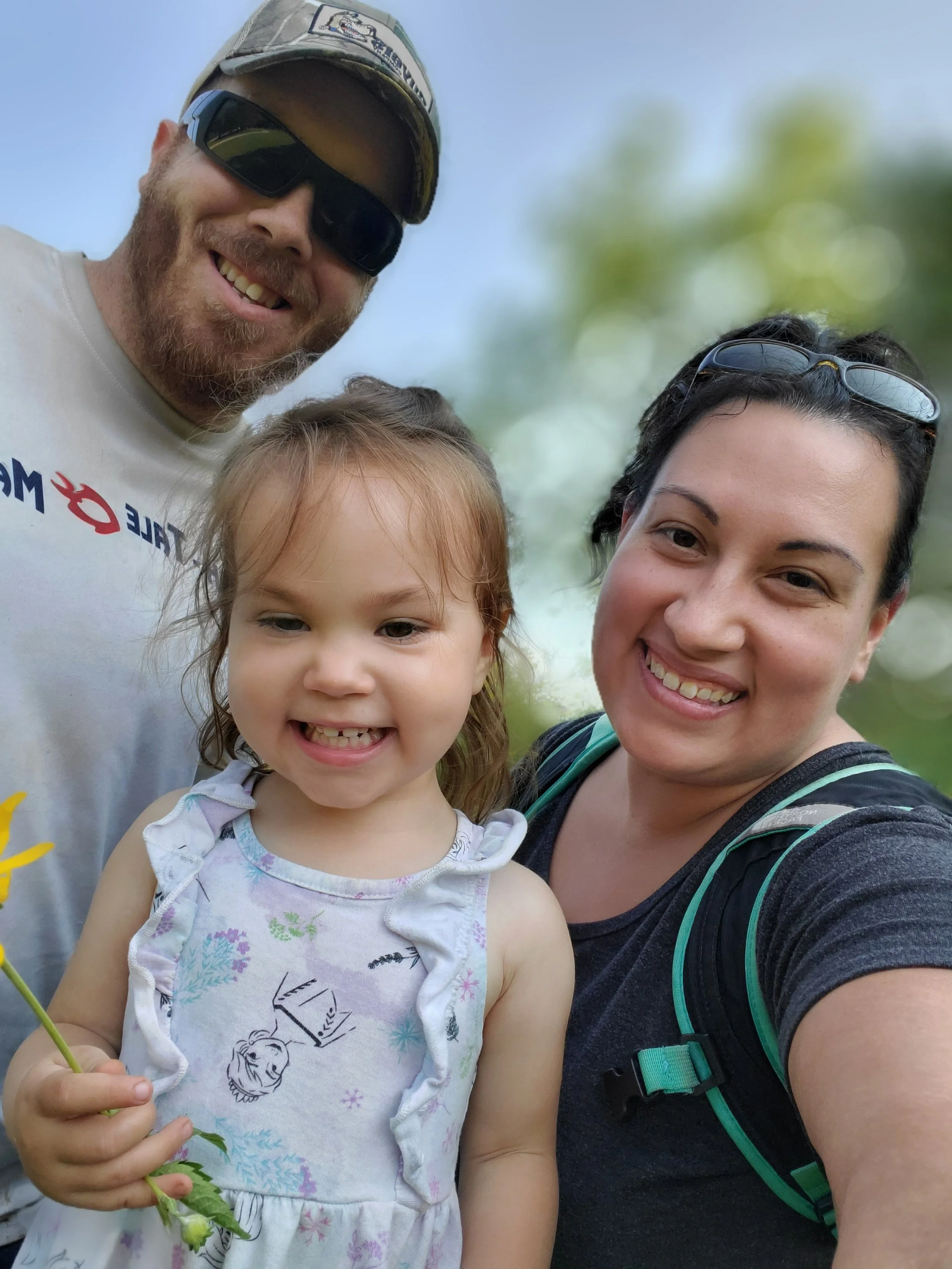 Women, men, and child all smilimg looking at camera