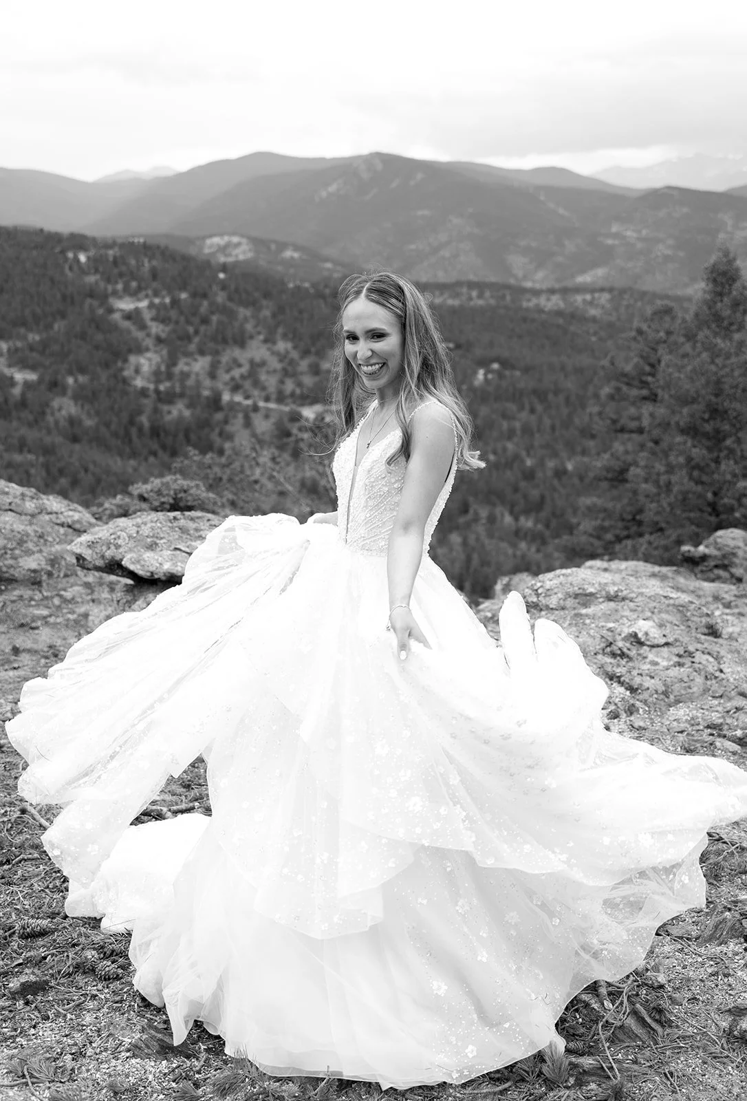 black and white bridal portrait in the Colorado mountains where the bride twirls her dress