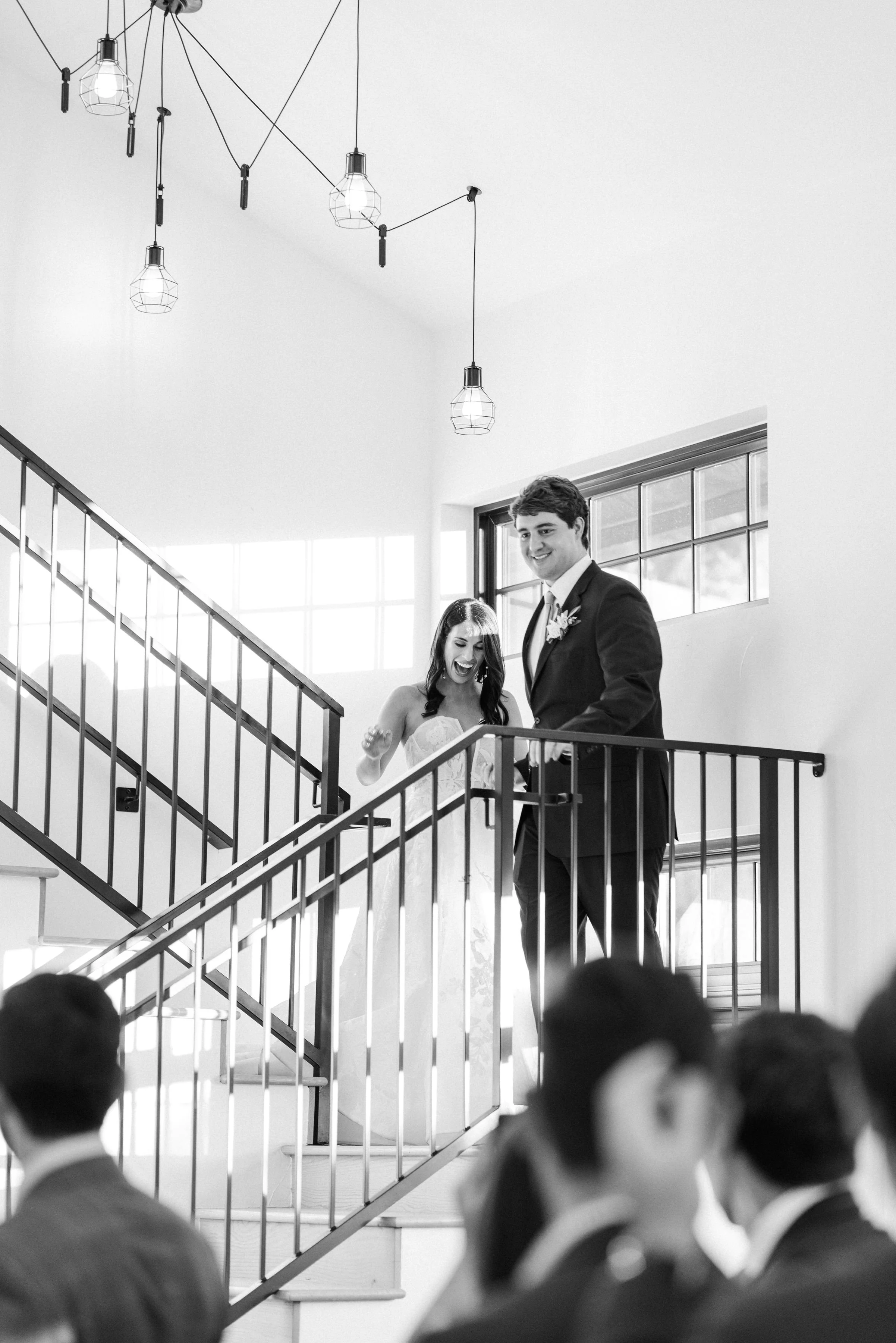 Couples grand entrance inspiration, descending down a staircase, smiling