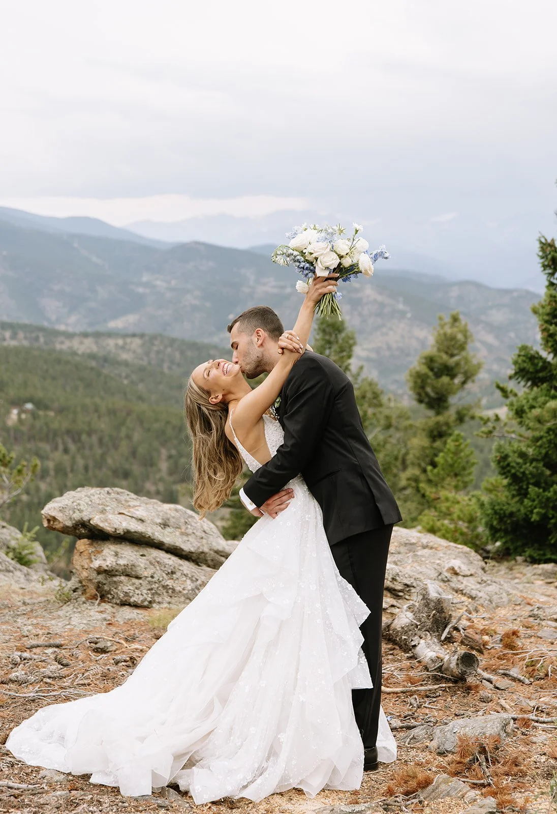 Joyful first look on a mountain with a bride in a ballgown and a groom in a black suit