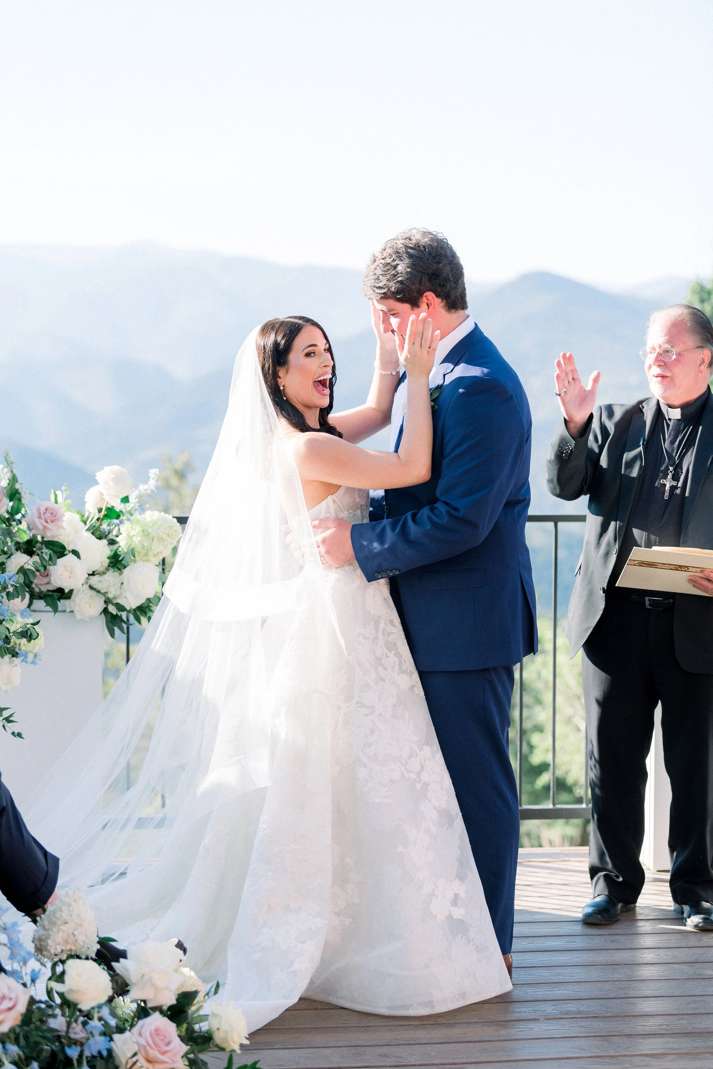 After the first kiss with amazing mountain ceremony views. The bride and groom are smiling and laughing.