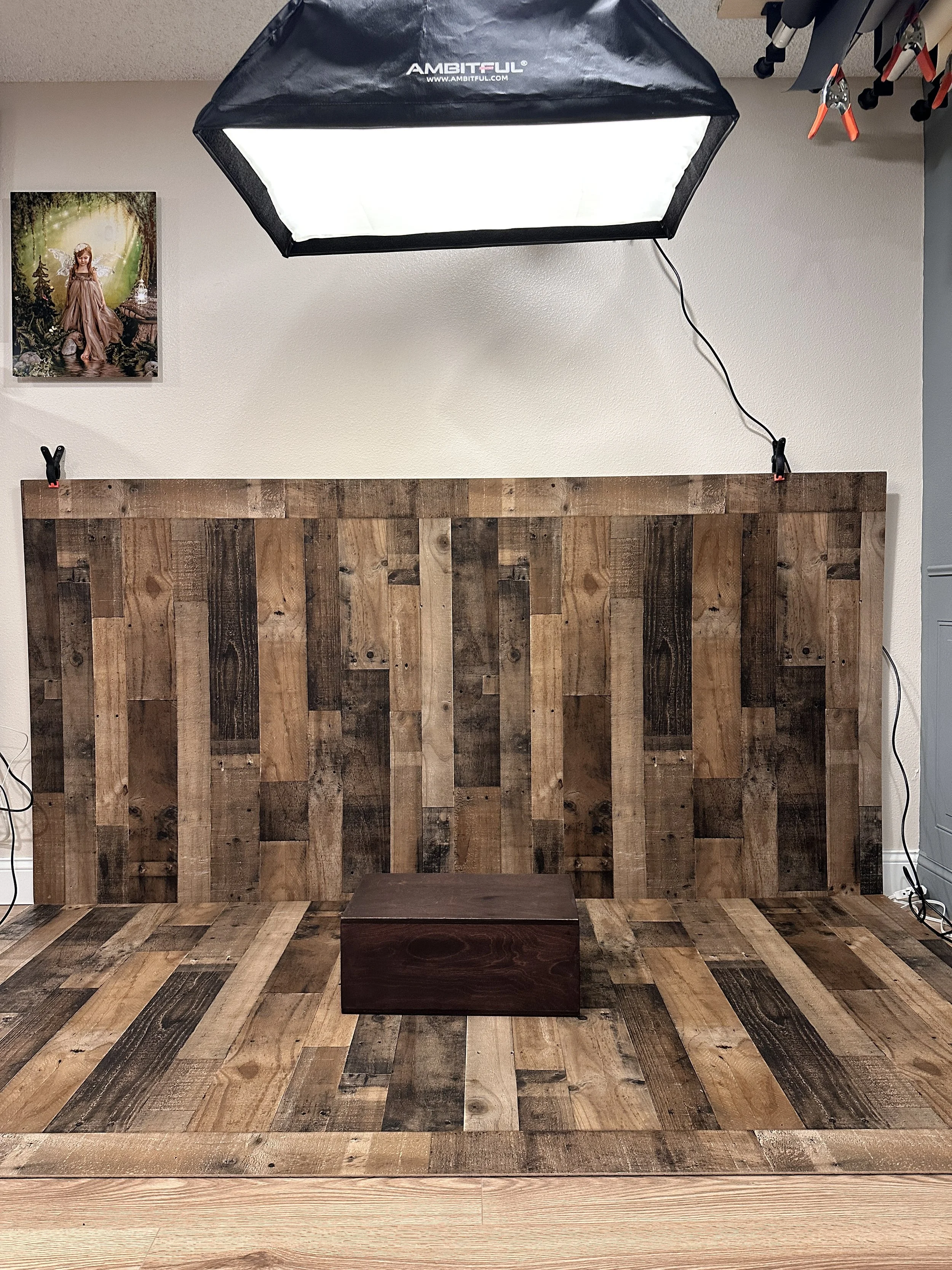 Wood wall and floor with an apple box on it and a softbox above