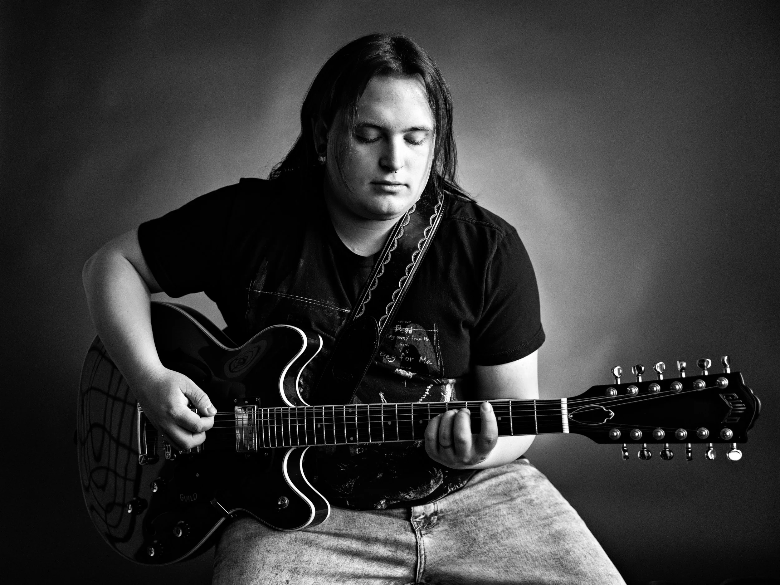 high school senior boy playing the guitar