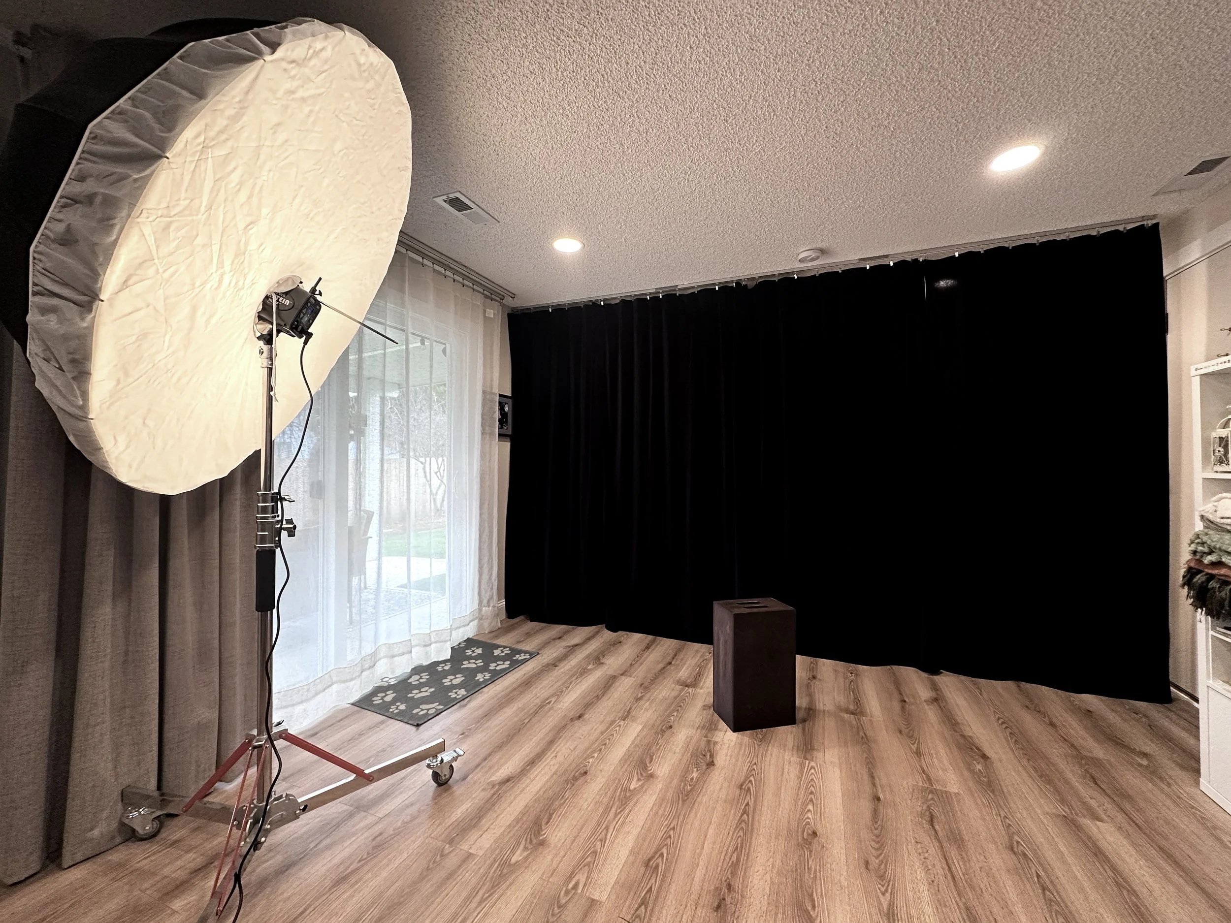 View of a black curtain backdrop with an apple box on the floor in front