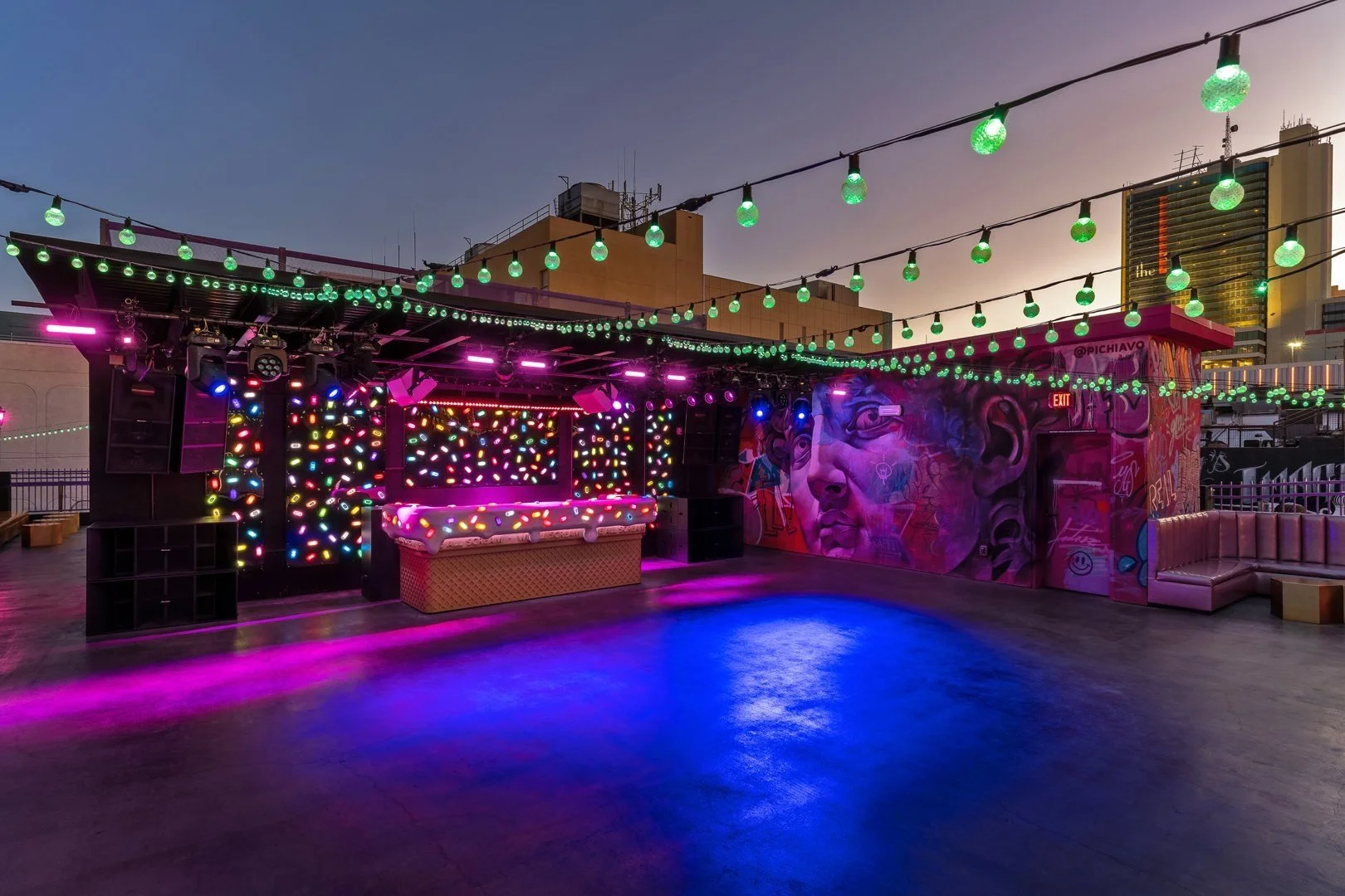 Rooftop bar with colorful lights and graffiti art