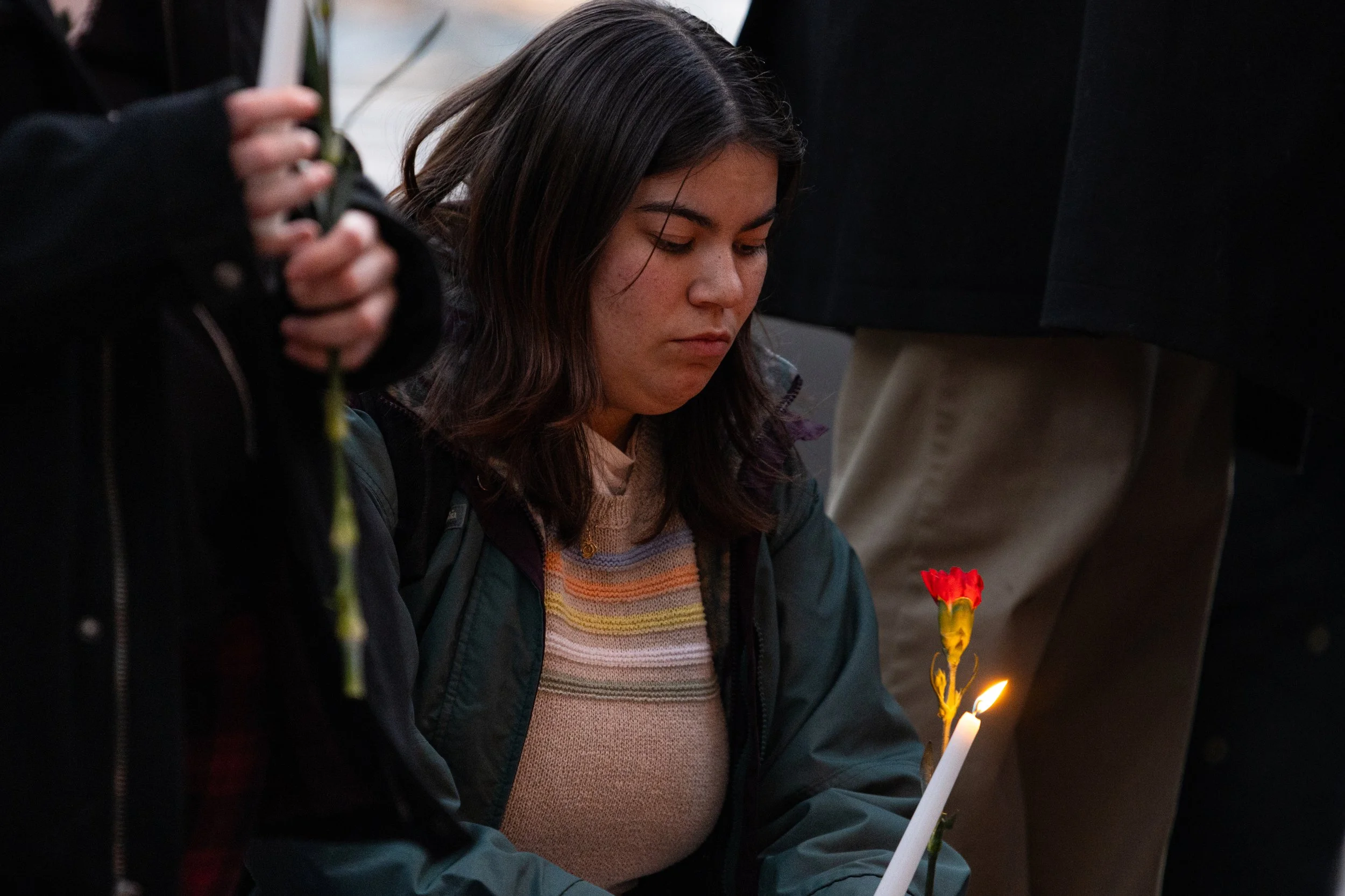 A protestor looks down at their candle outside of the Athens City Building on East Washington Street in Athens, Ohio, Feb. 19, 2024. The crowd was protesting the war in Gaza and pushing for the city of Athens to support a ceasefire deal. | For The Po
