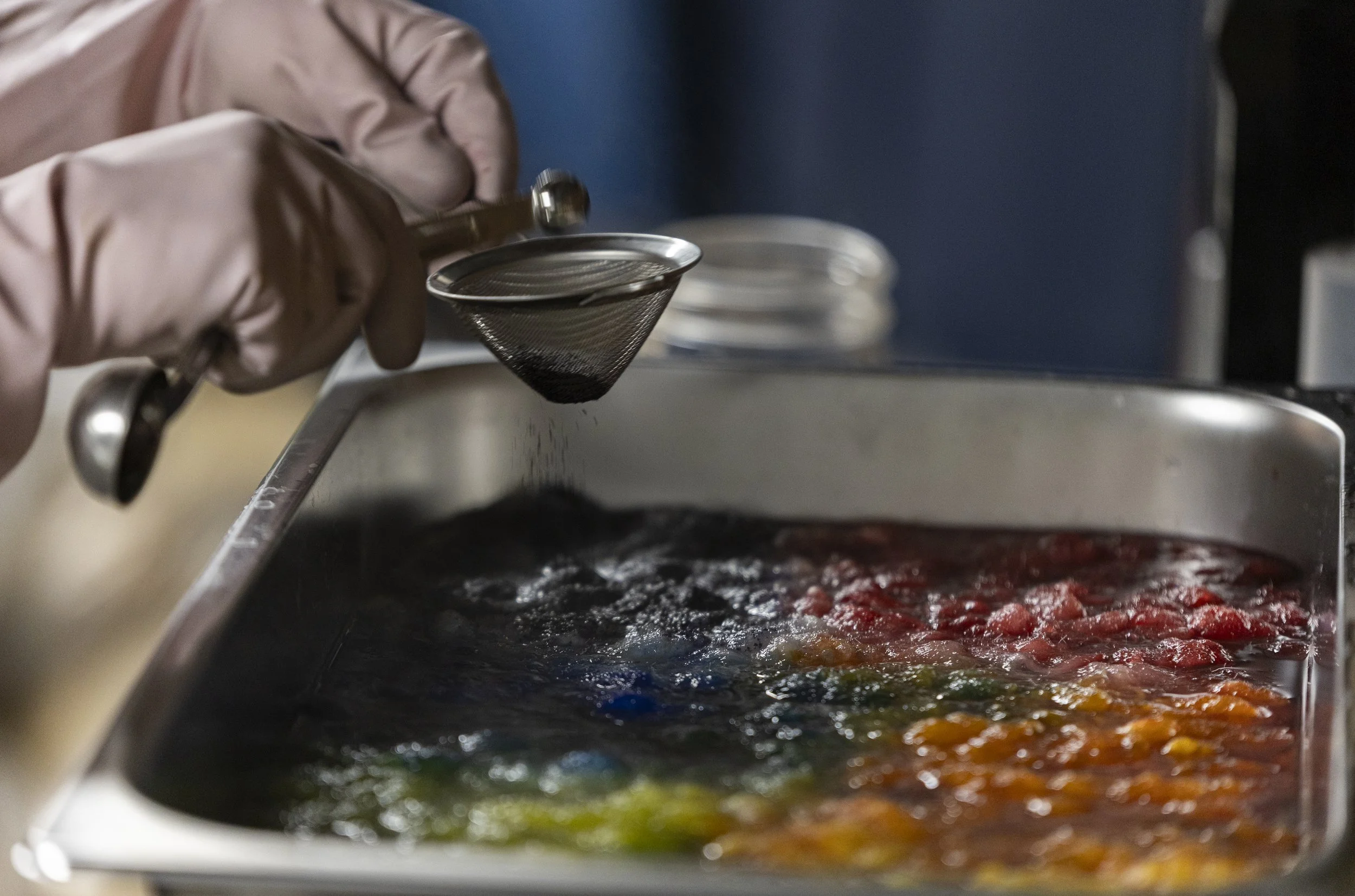 Lisa Heinz taps a blue dye into a rainbow pattern of wool in her basement in Athens, Ohio, September 2, 2025. "The kids really love this pattern," she said. "I always sell out of the rainbow."